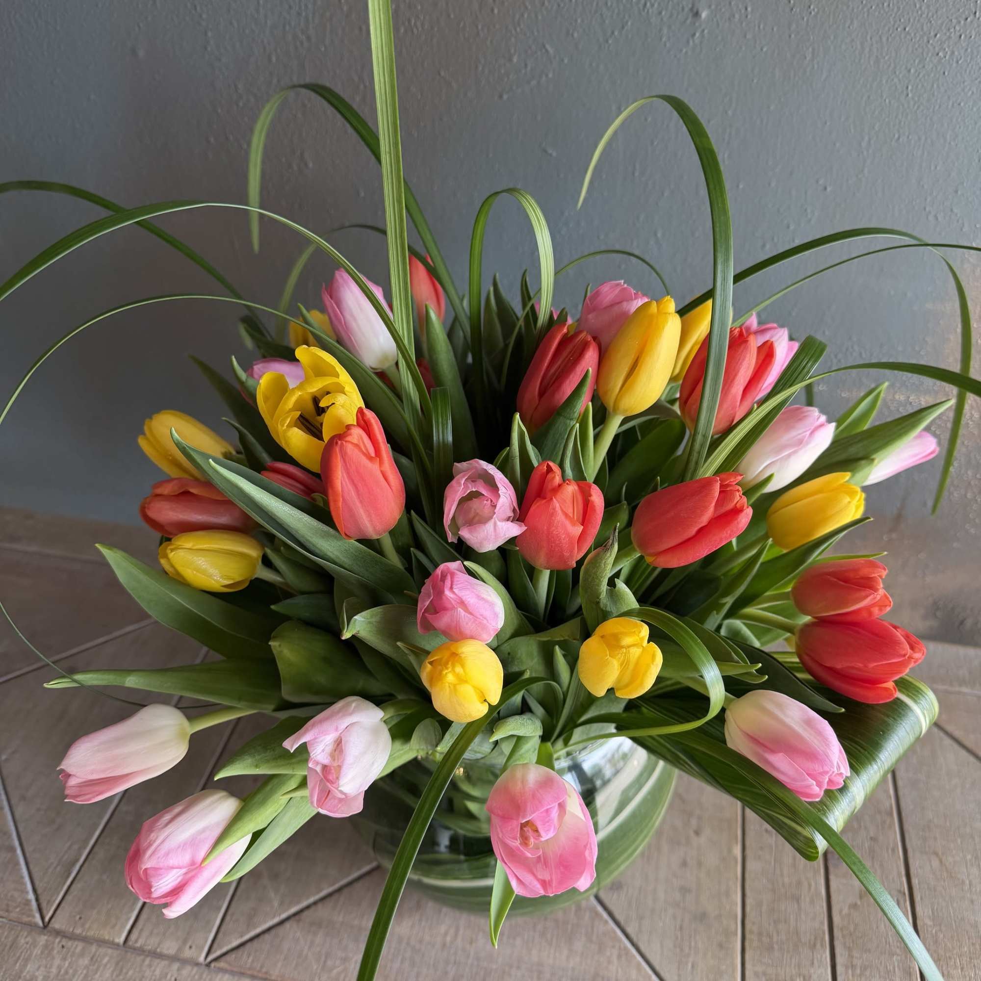 A bright cluster of twirling tulips in a variety of colors makes