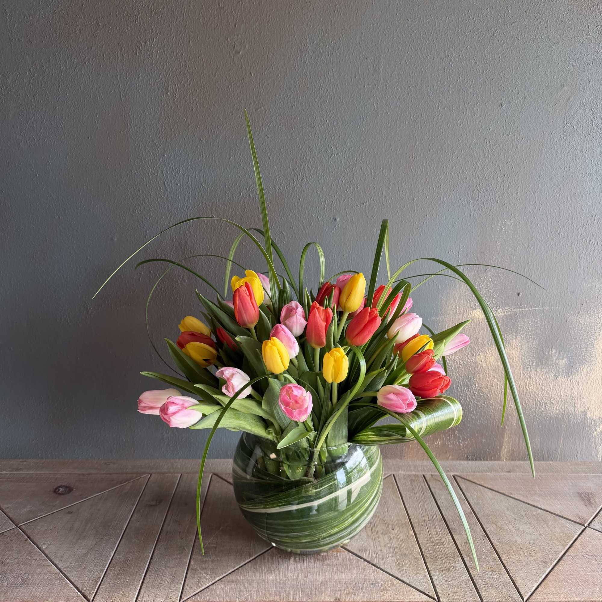 A bright cluster of twirling tulips in a variety of colors makes
