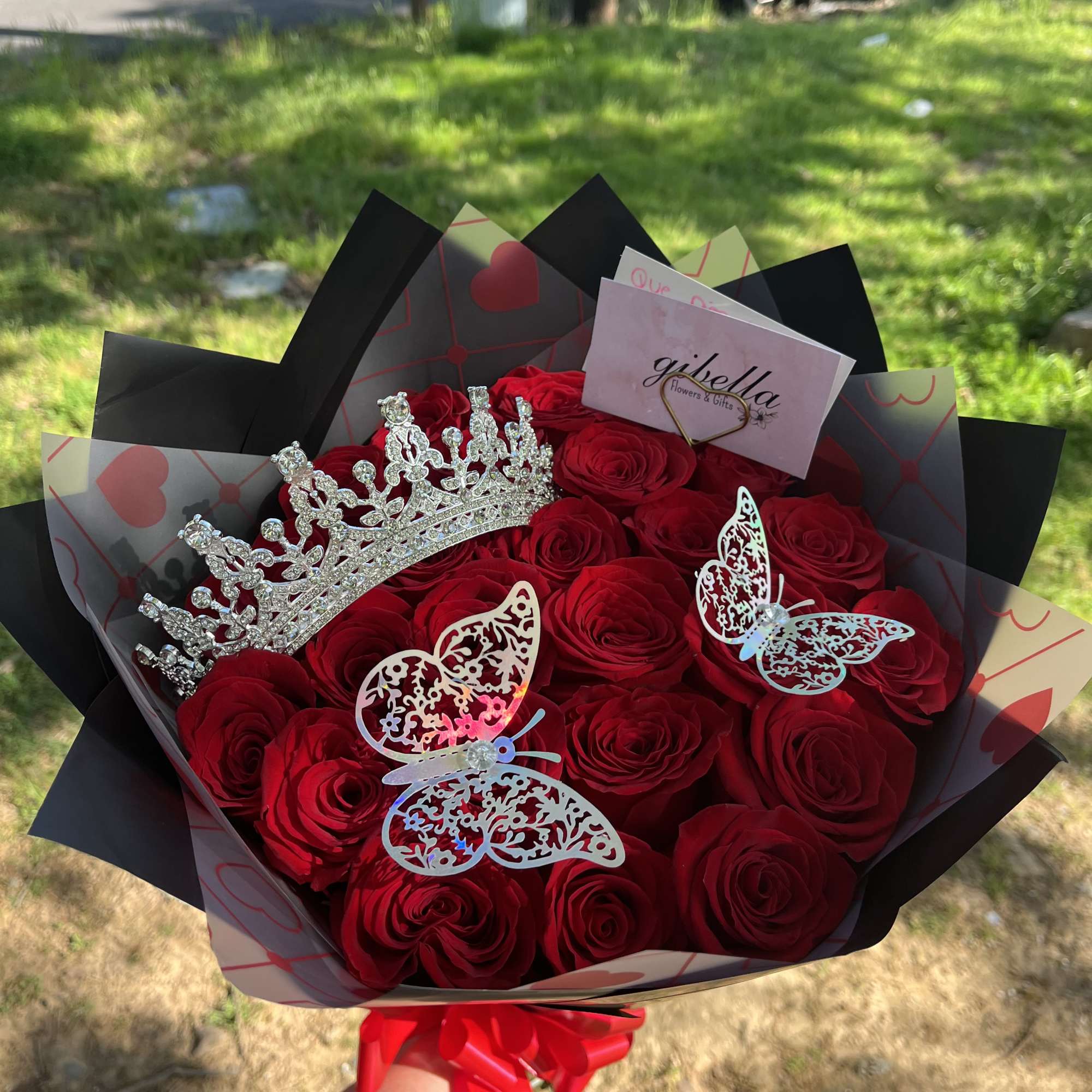 Bouquet of red roses with a jeweled crown and butterfly decorations