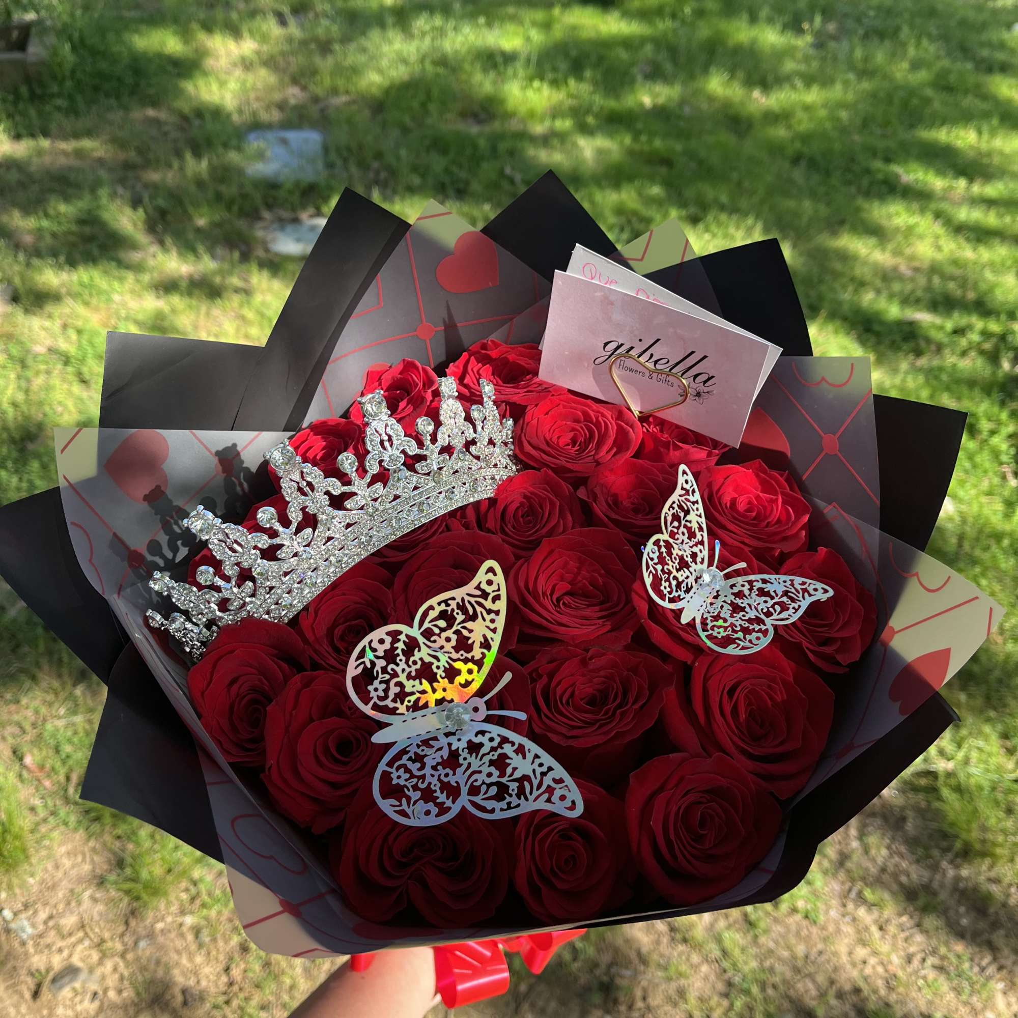 Bouquet of red roses with a silver crown and butterfly decorations