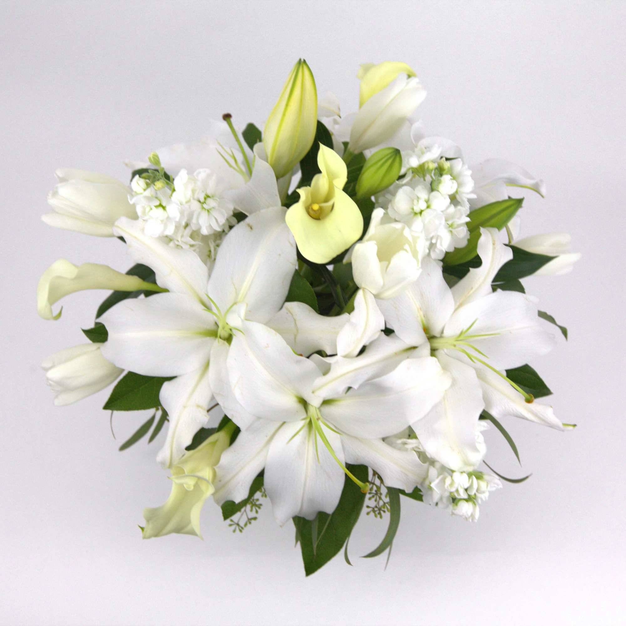 White lilies and pale yellow calla lilies in a bouquet