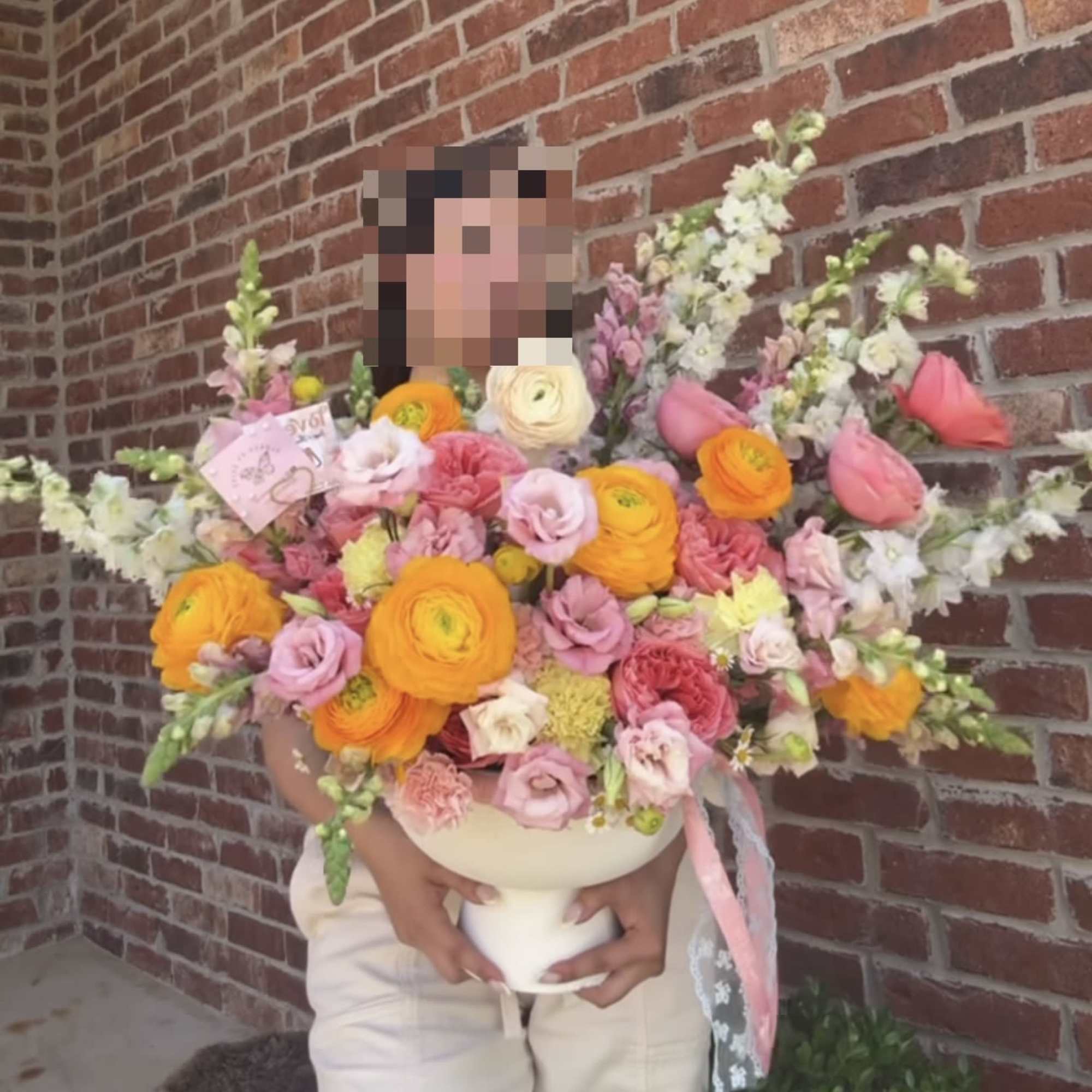 Large bouquet of pink, orange, and white flowers in a white vase