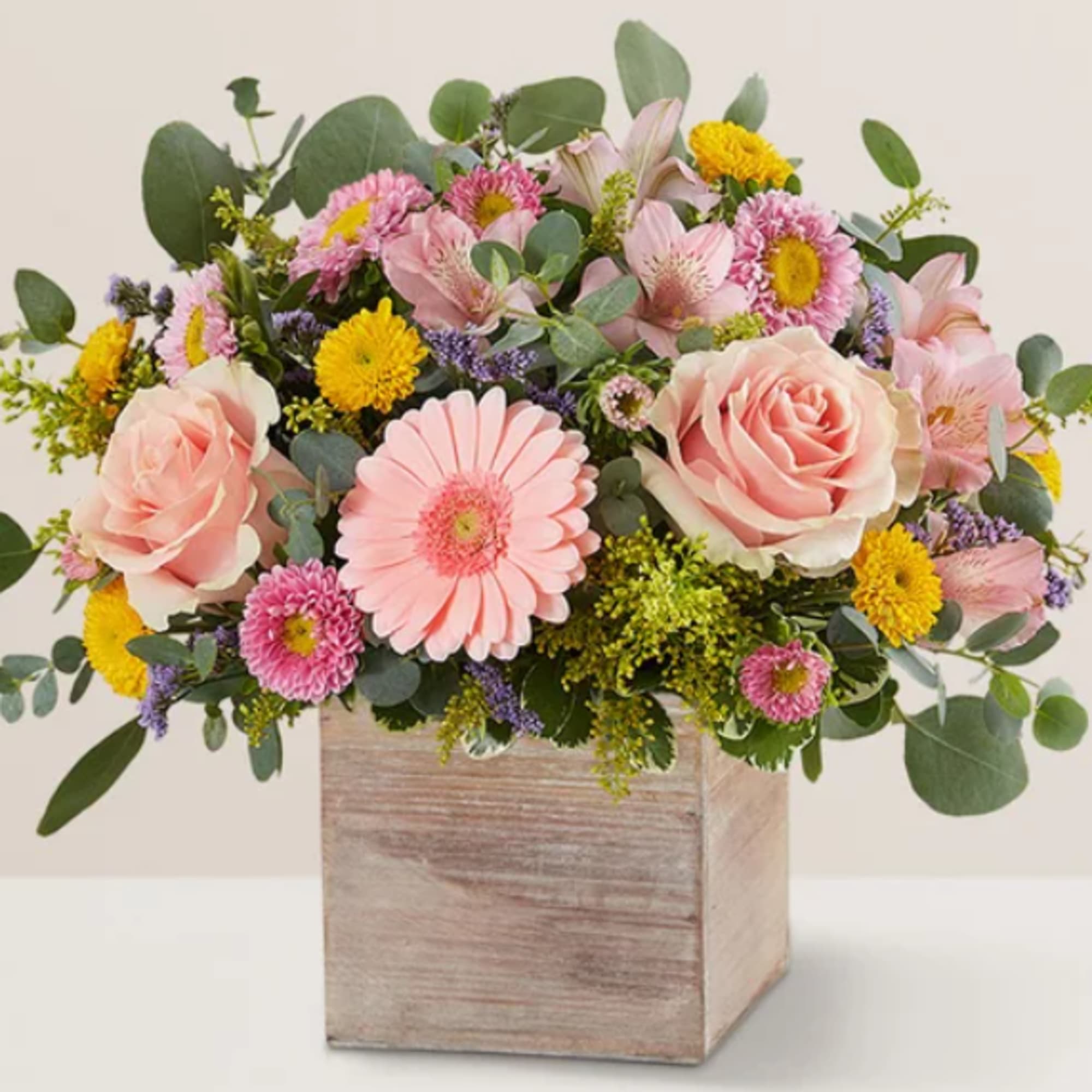 Pink roses and mixed daisies in a wooden box