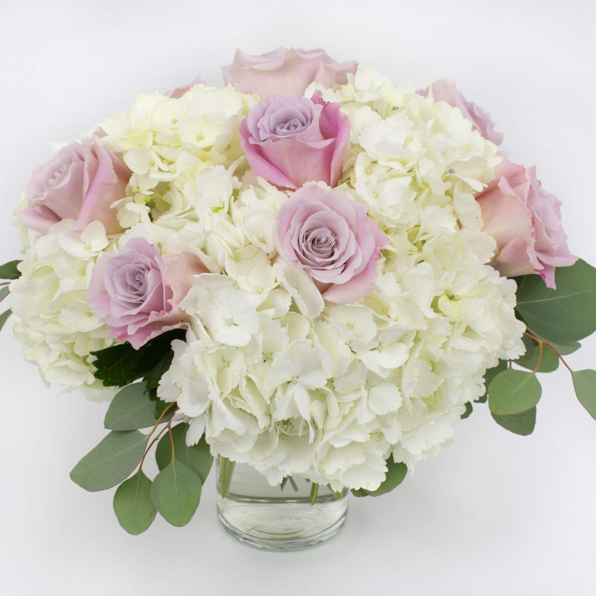 Pink roses and white hydrangeas in a clear glass vase