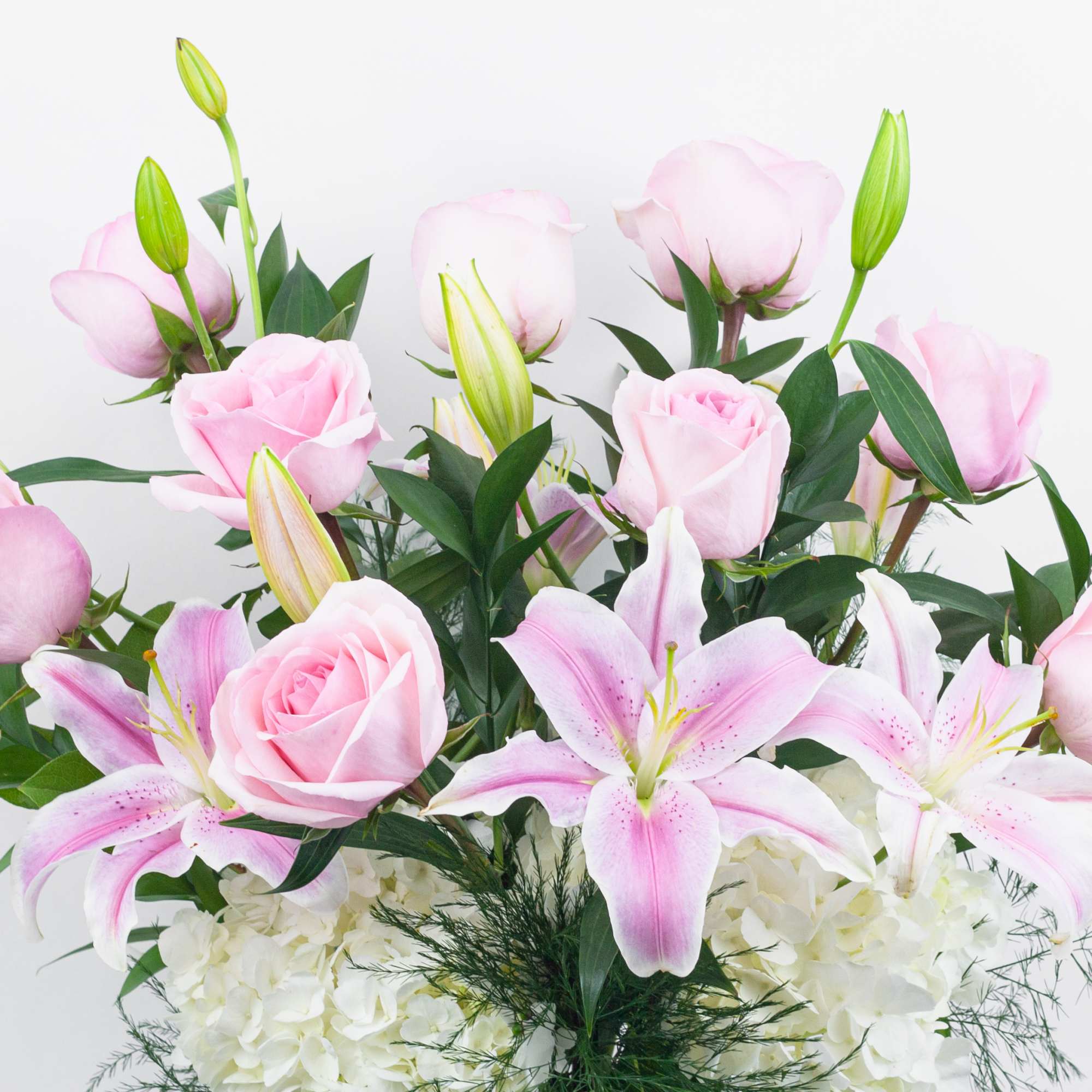 Pink roses and lilies arranged with white hydrangeas