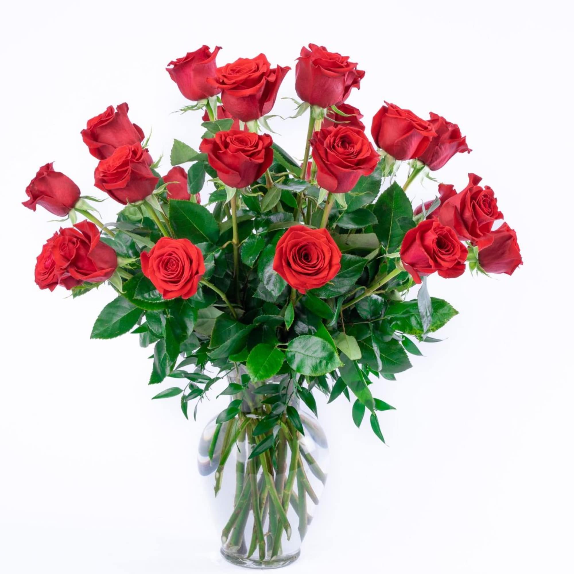 Tall bouquet of long-stemmed red roses in a clear glass vase