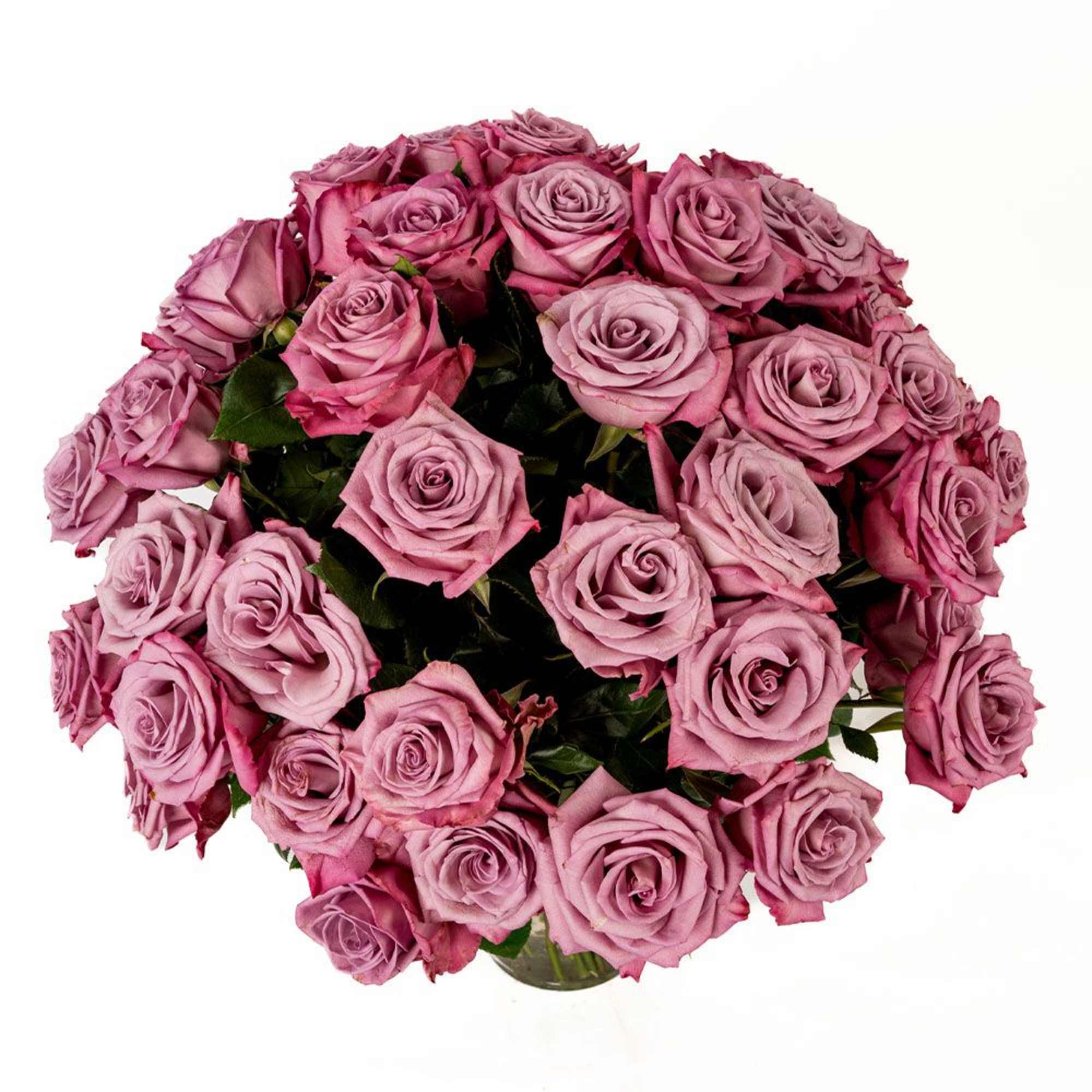 Large dome-shaped bouquet of mauve and dusty pink roses in a clear glass vase