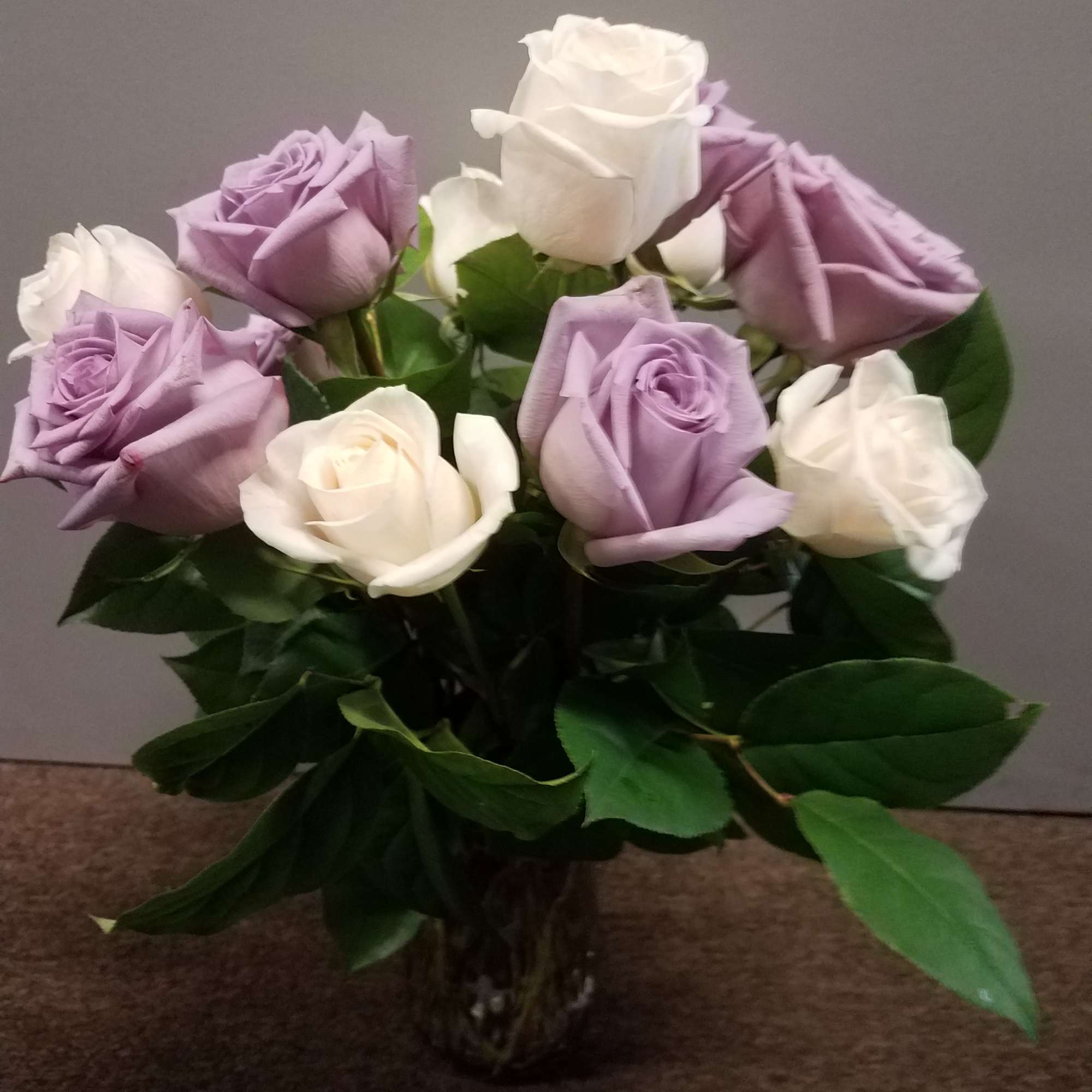 Bouquet of lavender and white roses in a clear glass vase