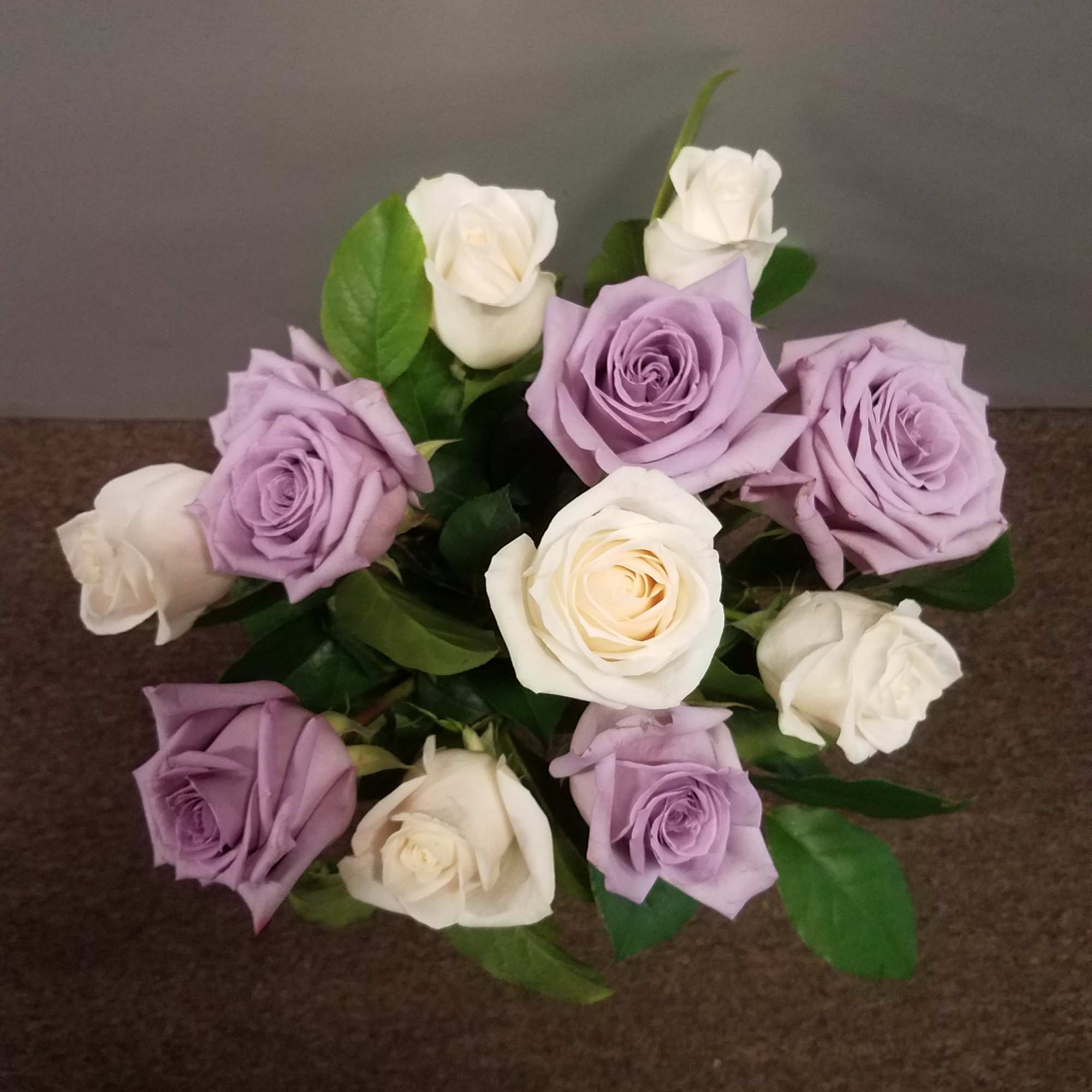 Bouquet of lavender and white roses with green leaves