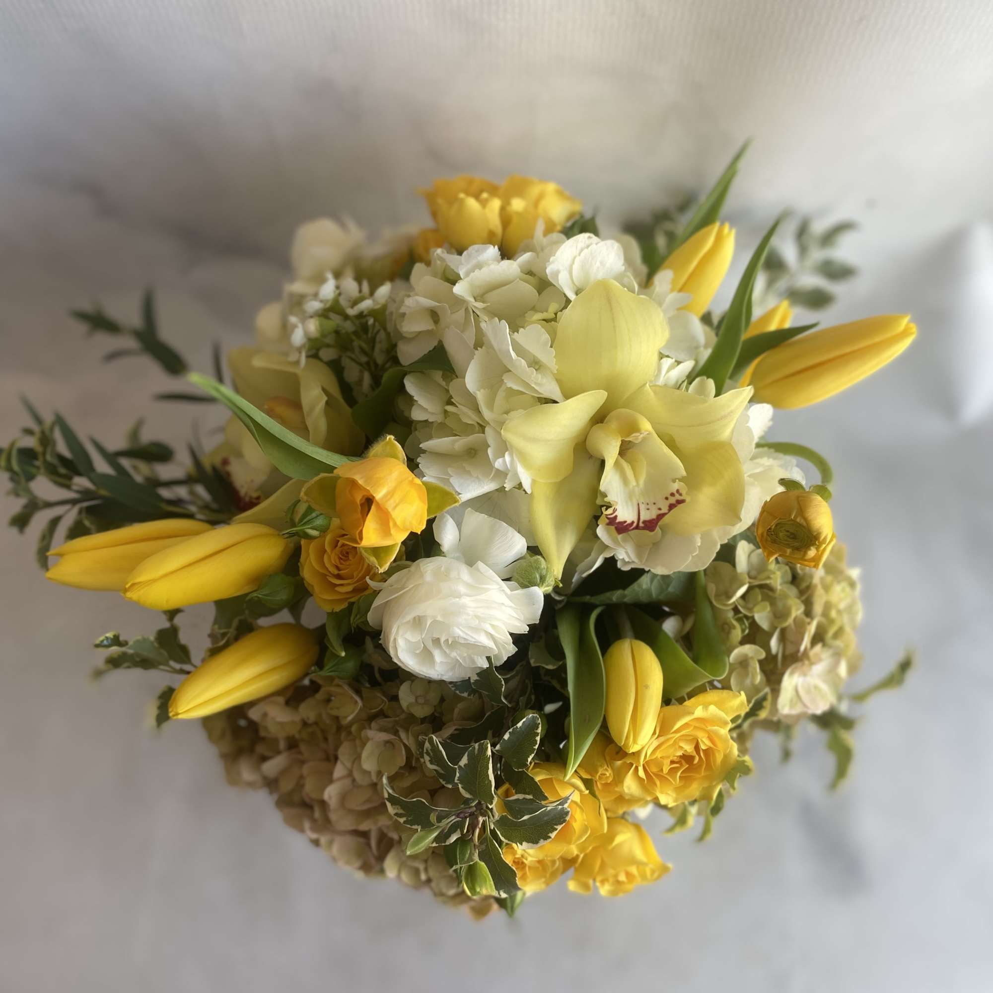 Yellow and white bouquet with tulips, orchids, and hydrangeas