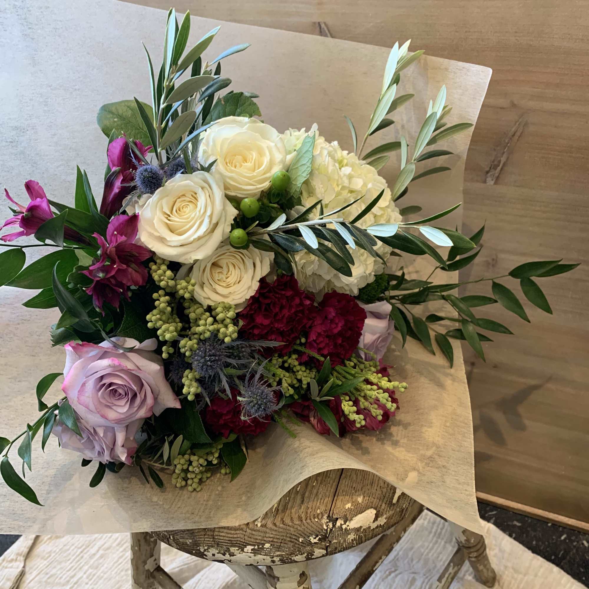 Bouquet of cream and lavender roses with magenta flowers and greenery