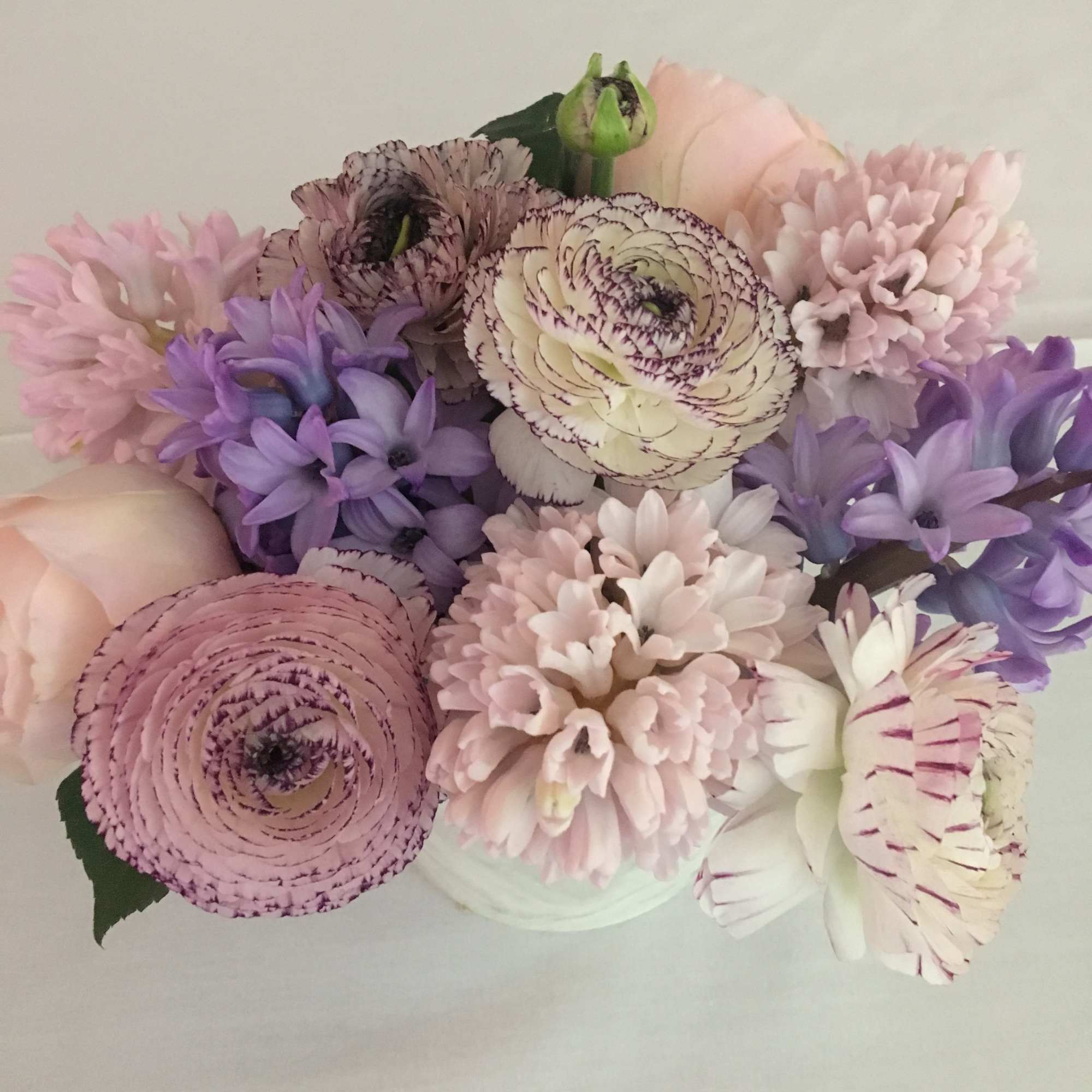 Pastel bouquet of pink, lavender, and white flowers in a vase