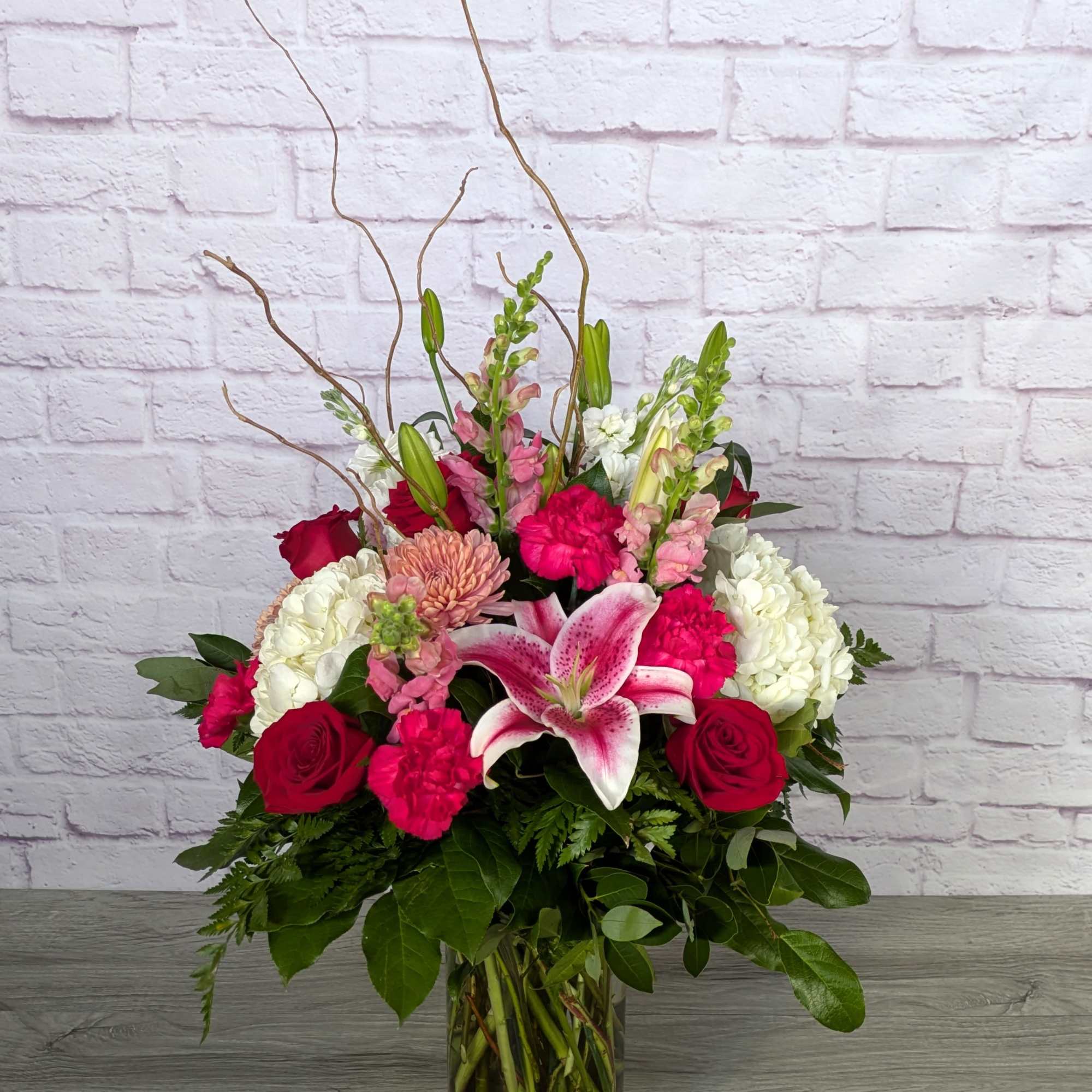 Mixed bouquet of pink and white flowers in a glass vase