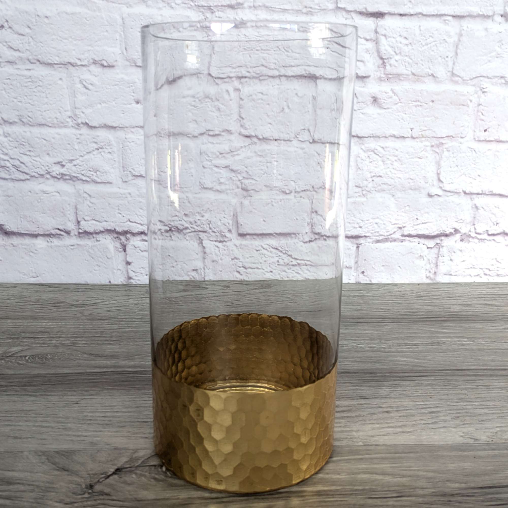 Tall clear glass vase with a hammered gold base