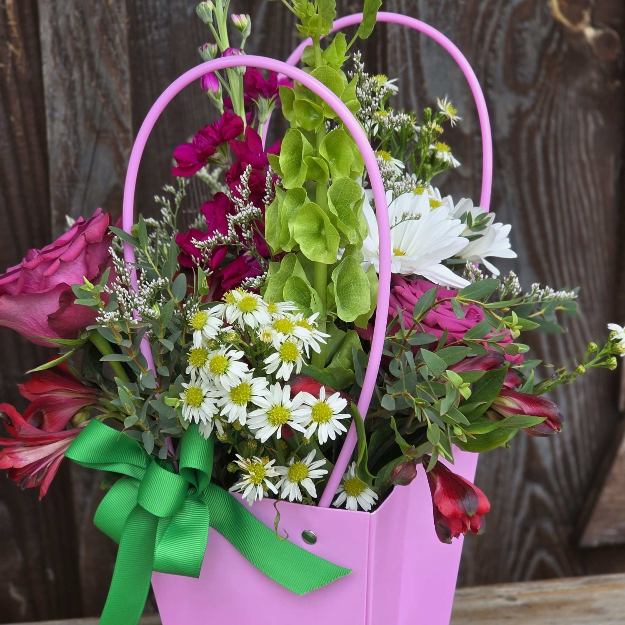 A fresh, designer&rsquo;s choice arrangement tucked into a sturdy cardboard basket with