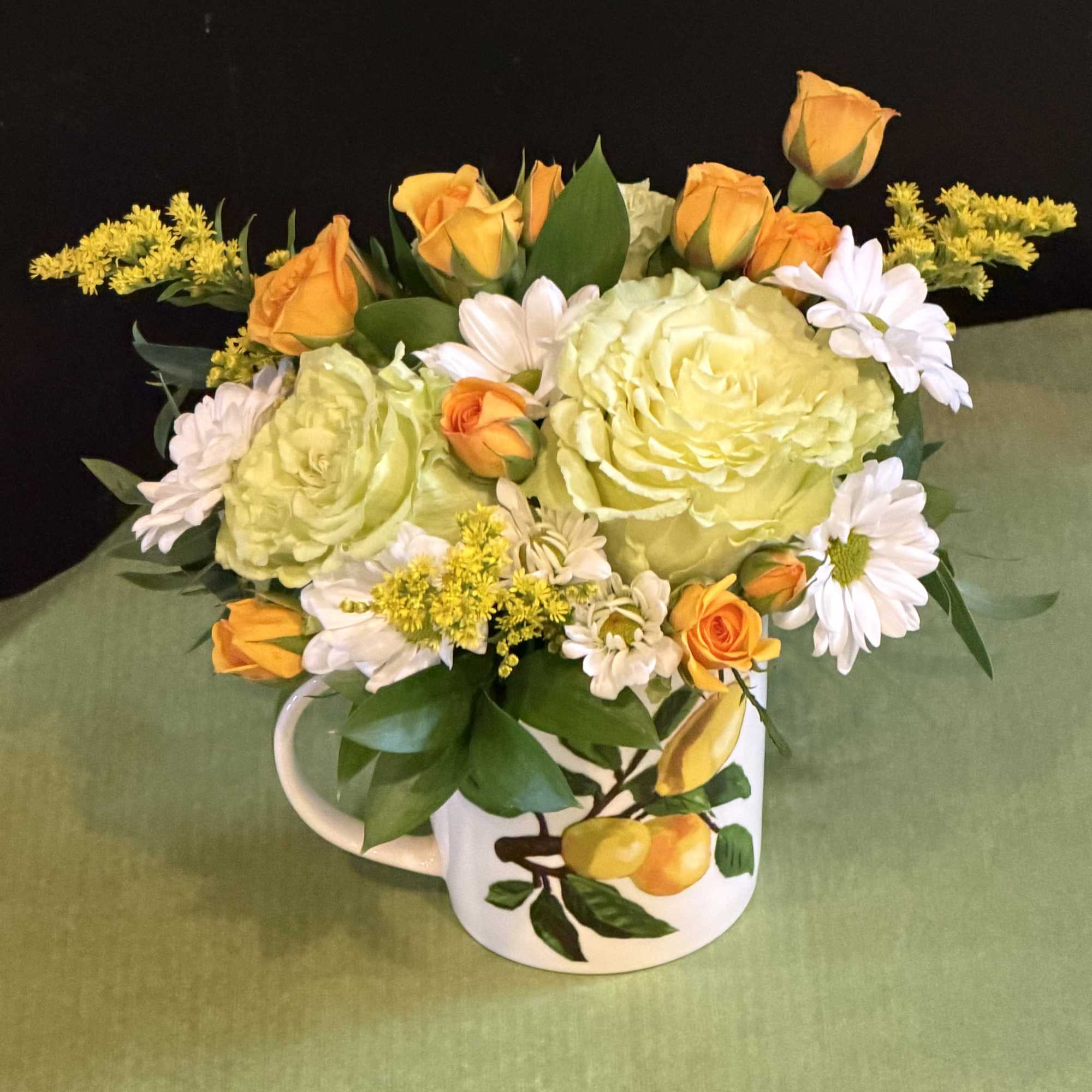 Bright and refreshing floral arrangement in a charming lemon-print mug. Features soft