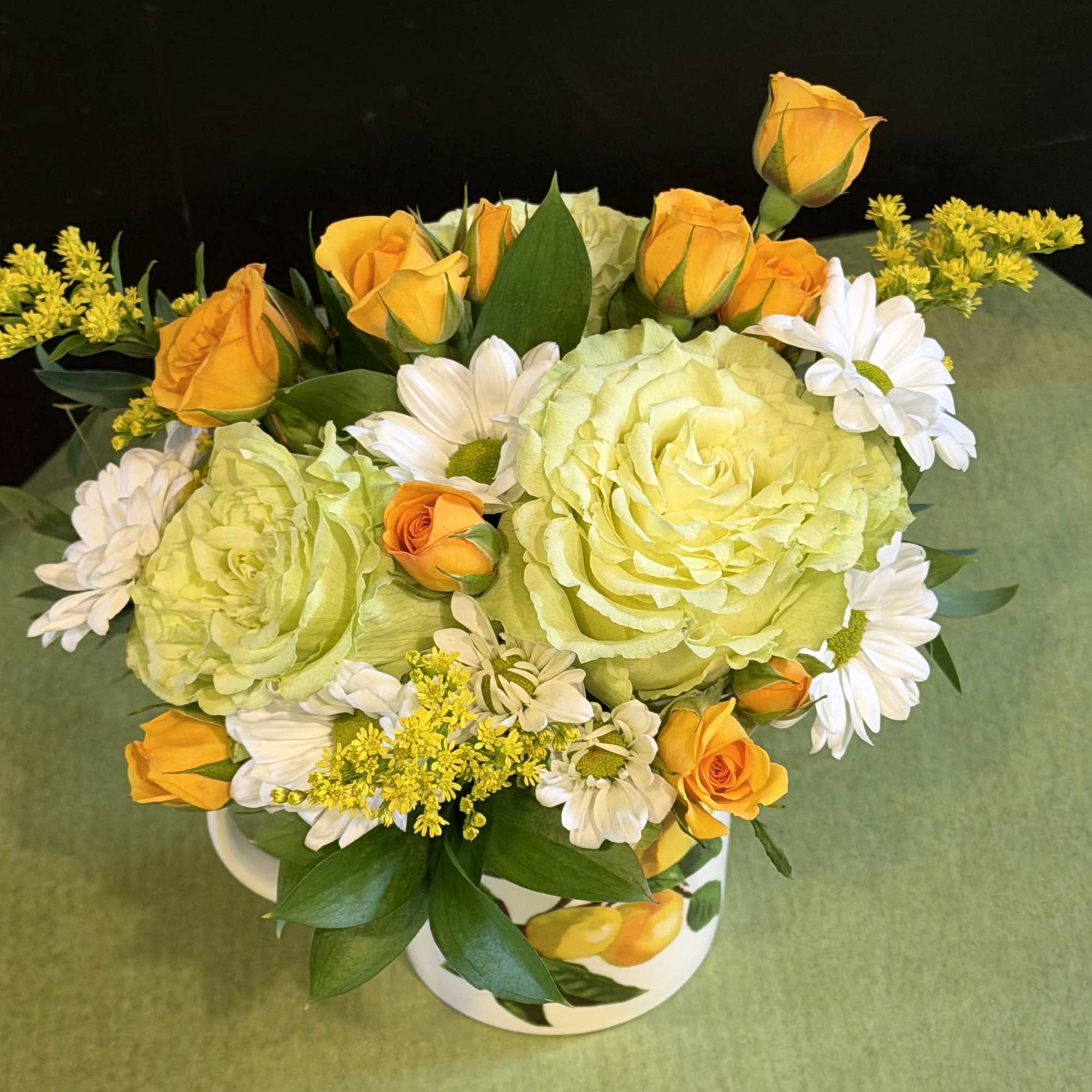 Bright and refreshing floral arrangement in a charming lemon-print mug. Features soft