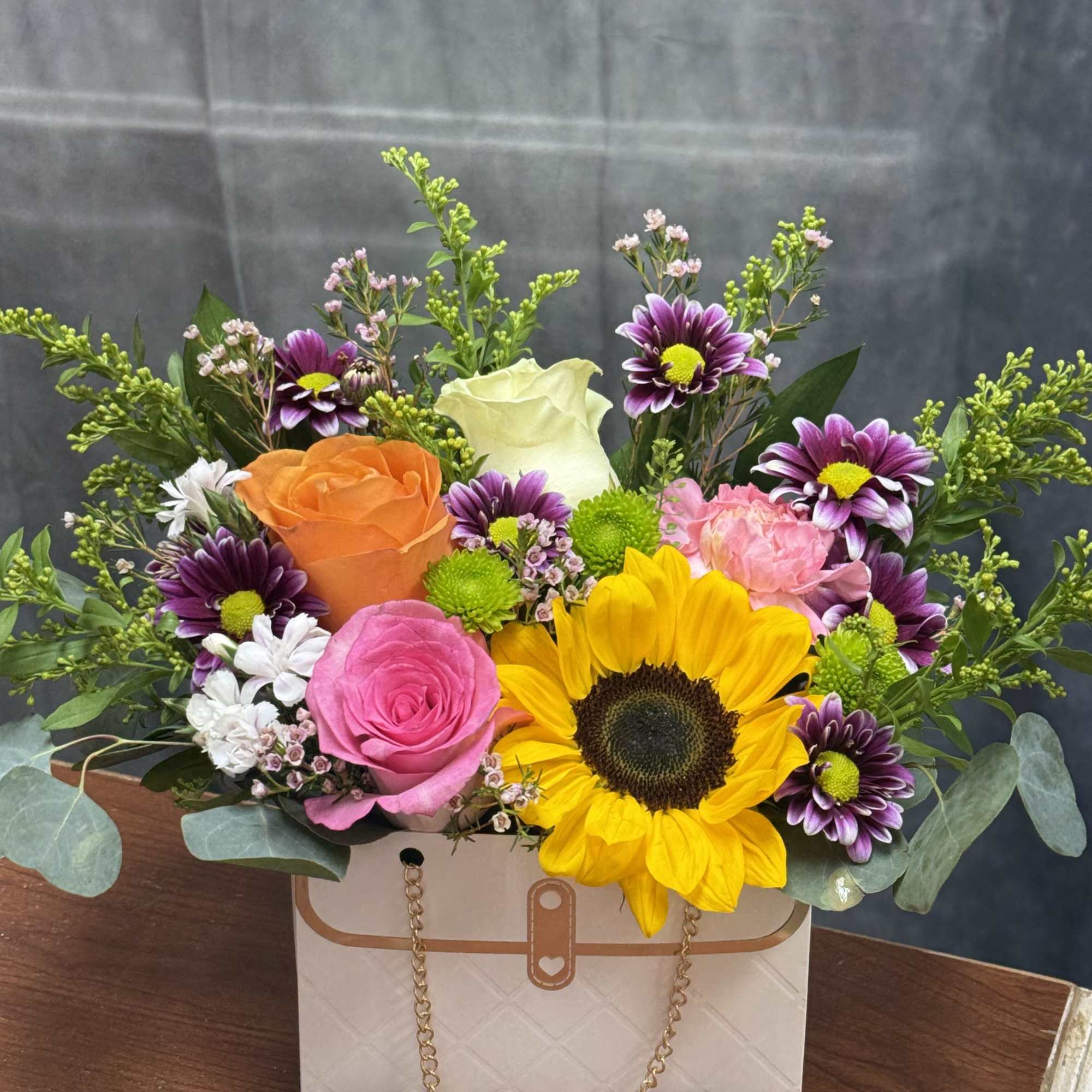 Sunflower-centered mixed  with pink, orange, purple and cream blooms in a