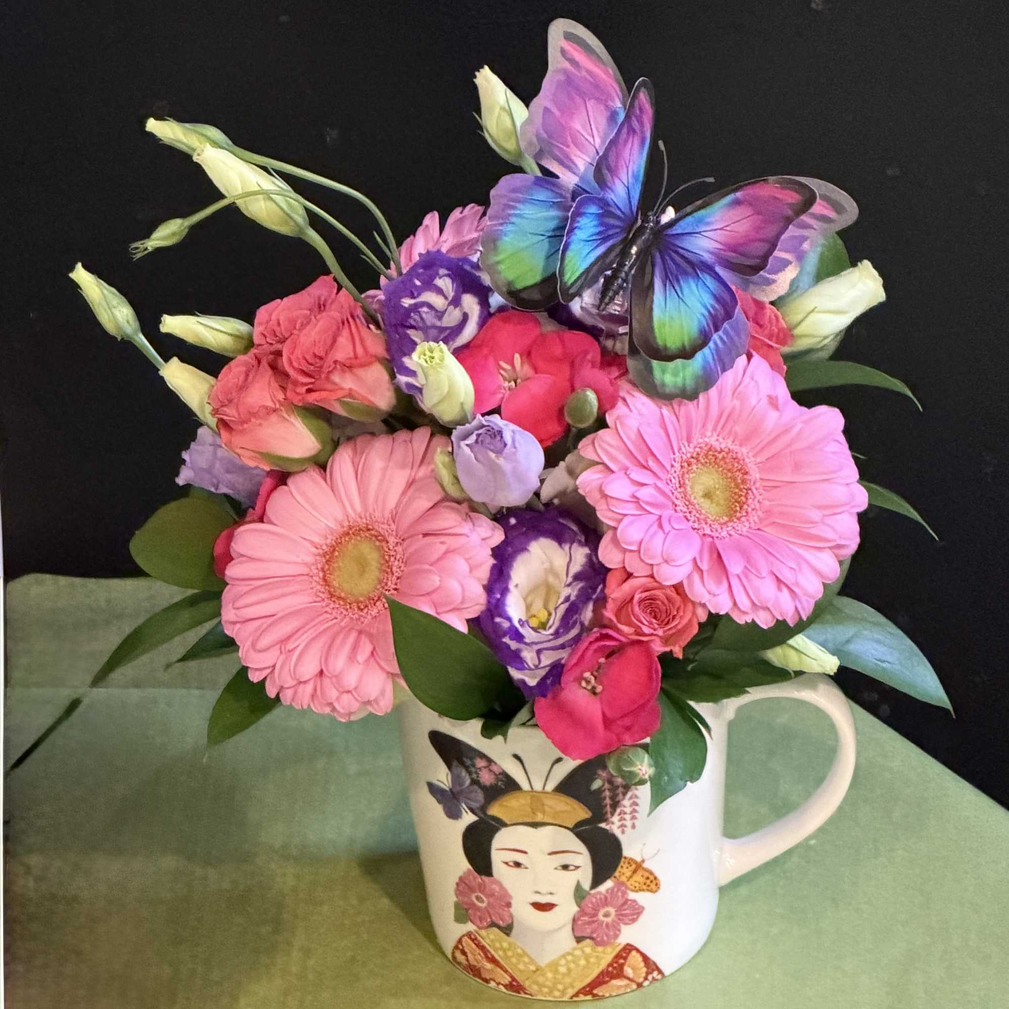 Elegant and vibrant arrangement in a beautifully illustrated mug, featuring pinks and