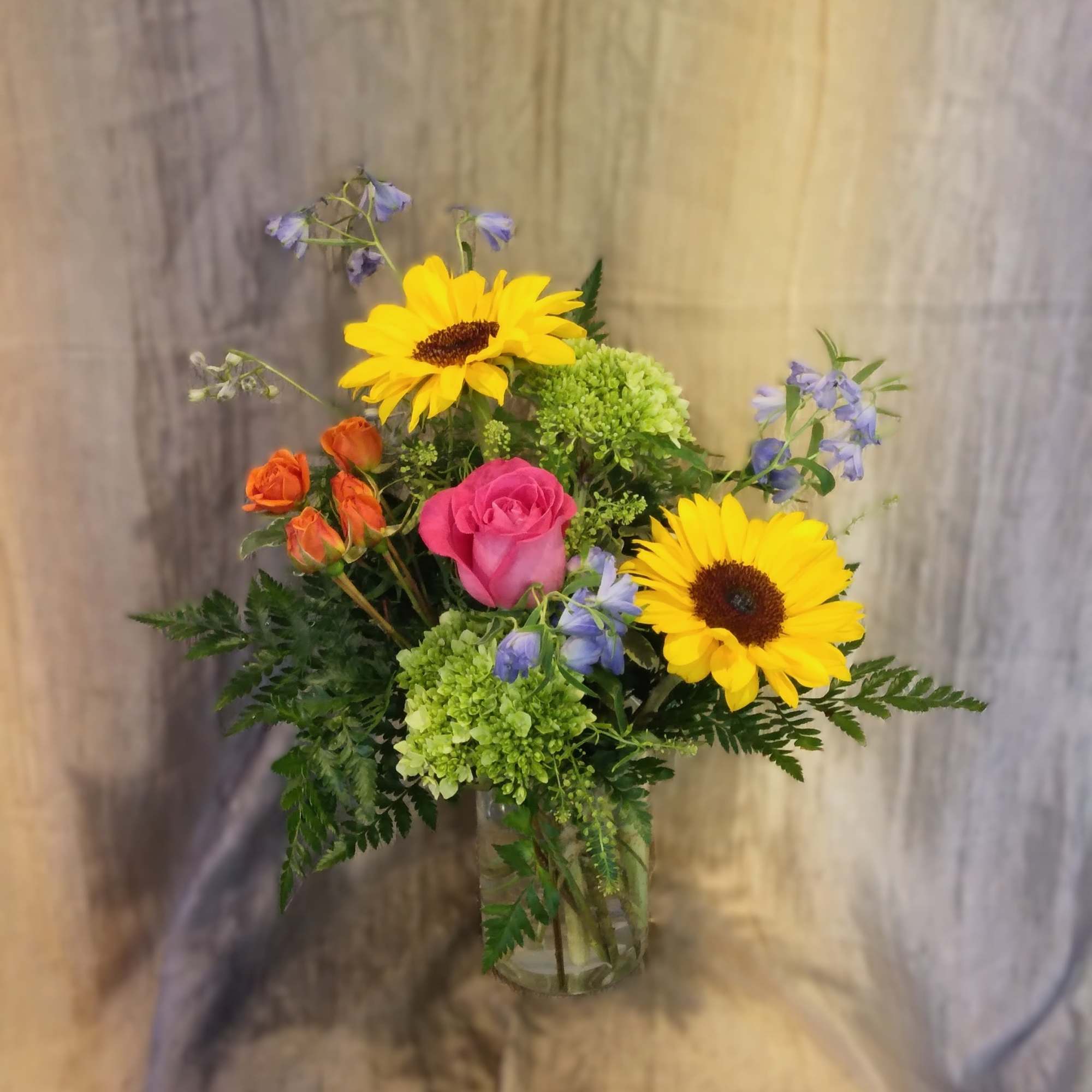 This bright and colorful arrangement brings brighter hues to your recipient's eye.