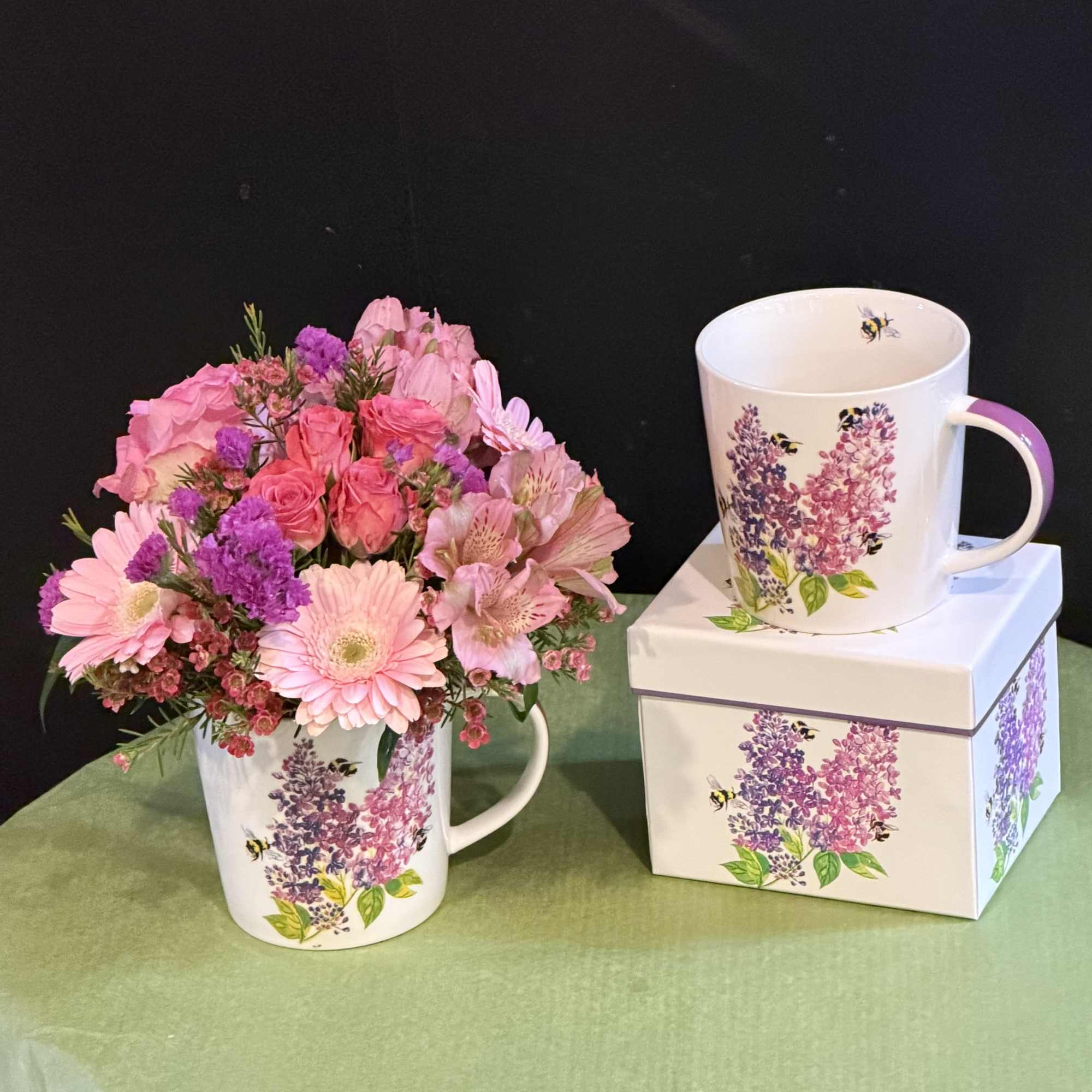 Soft and romantic arrangement in a floral lilac-themed mug, filled with pink