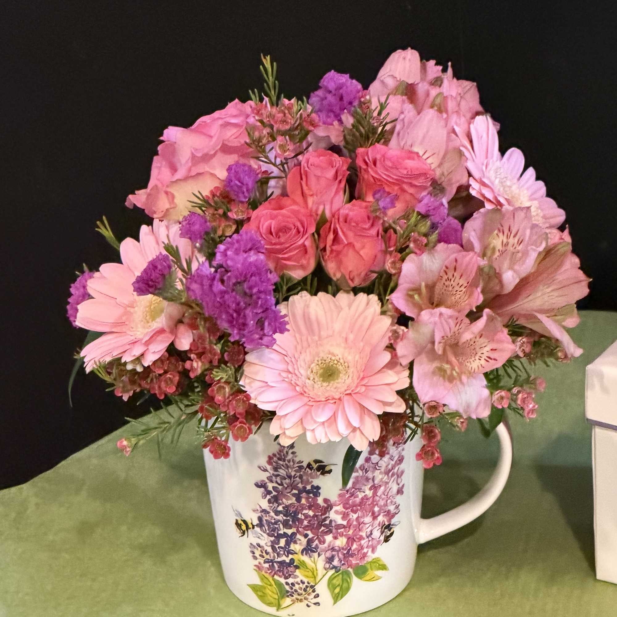 Soft and romantic arrangement in a floral lilac-themed mug, filled with pink