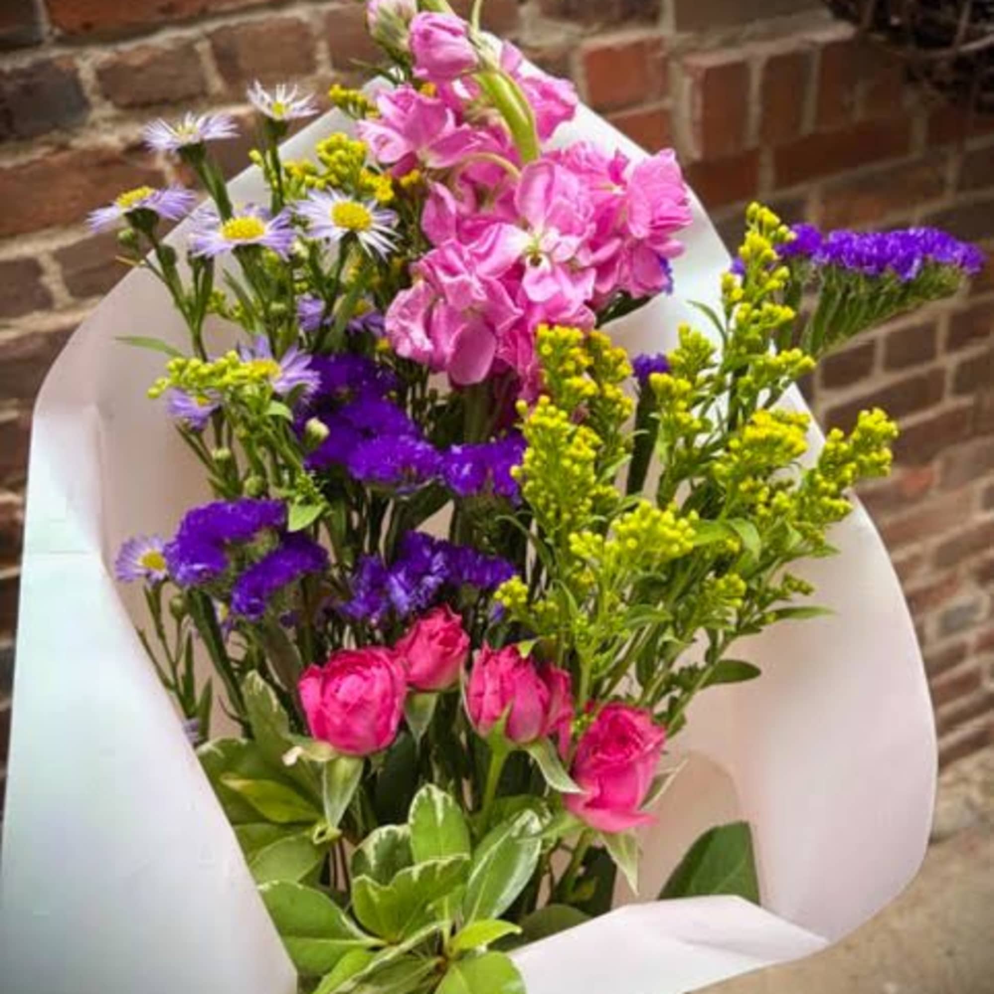 The "Mother's Hug" is a bright and colorful bouquet of loose flowers