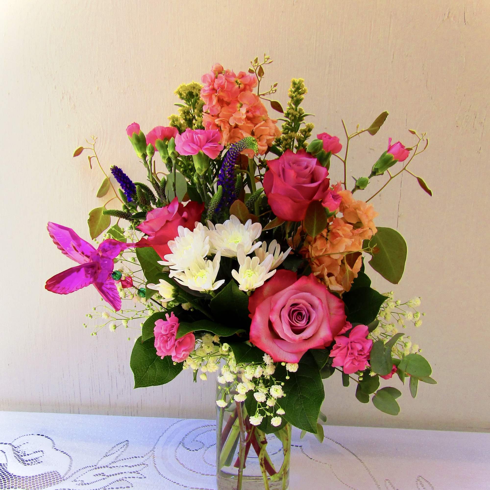 This floral bouquet comes with an acrylic hummingbird pick. We have 4