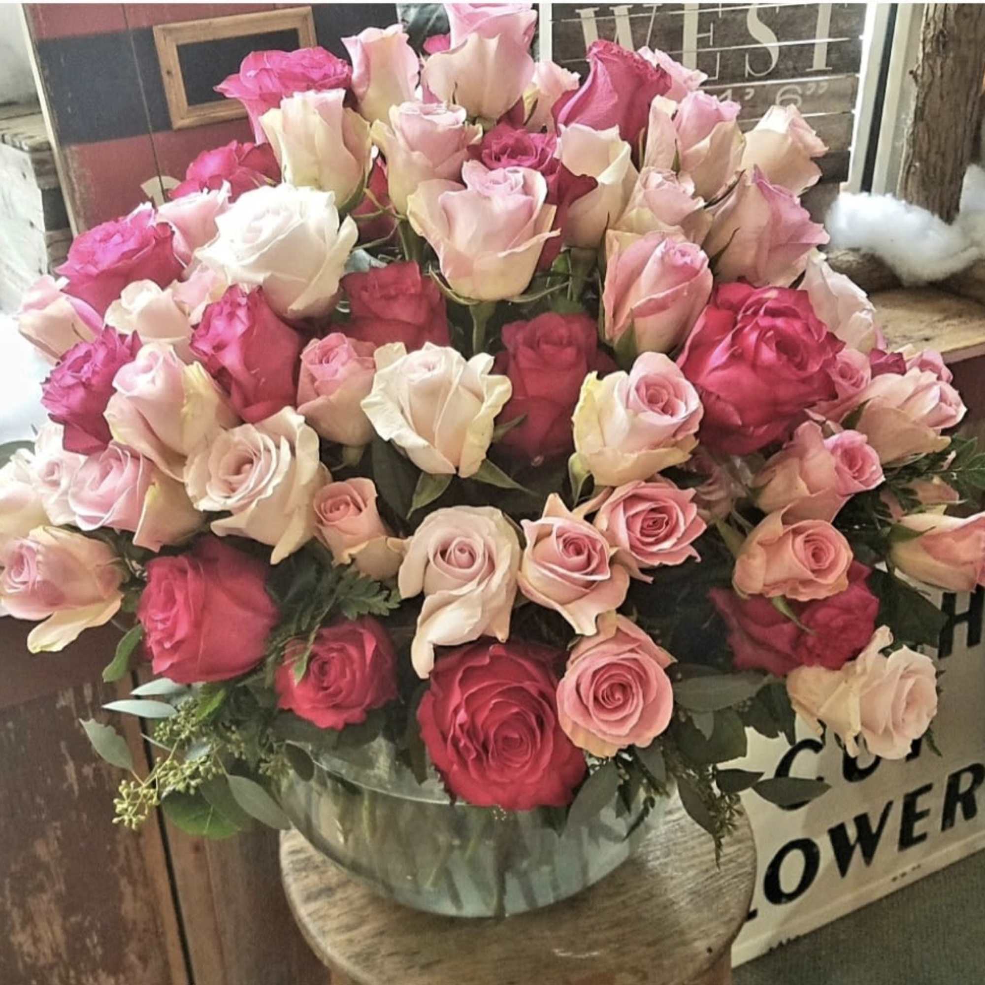 Large bouquet of pink and cream roses in a clear vase
