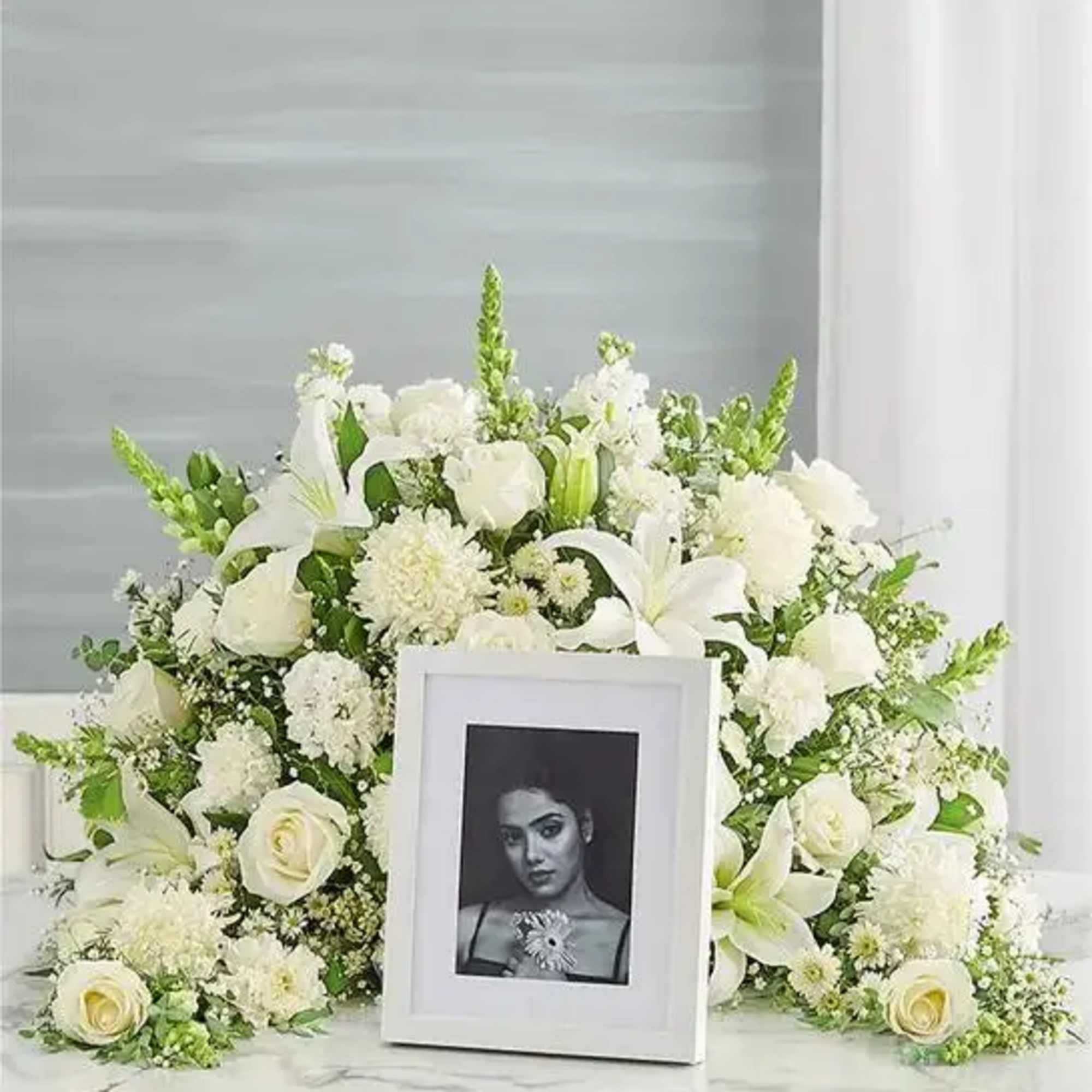 Express your heartfelt condolences with a beautiful floral tribute.One-sided arrangement of white