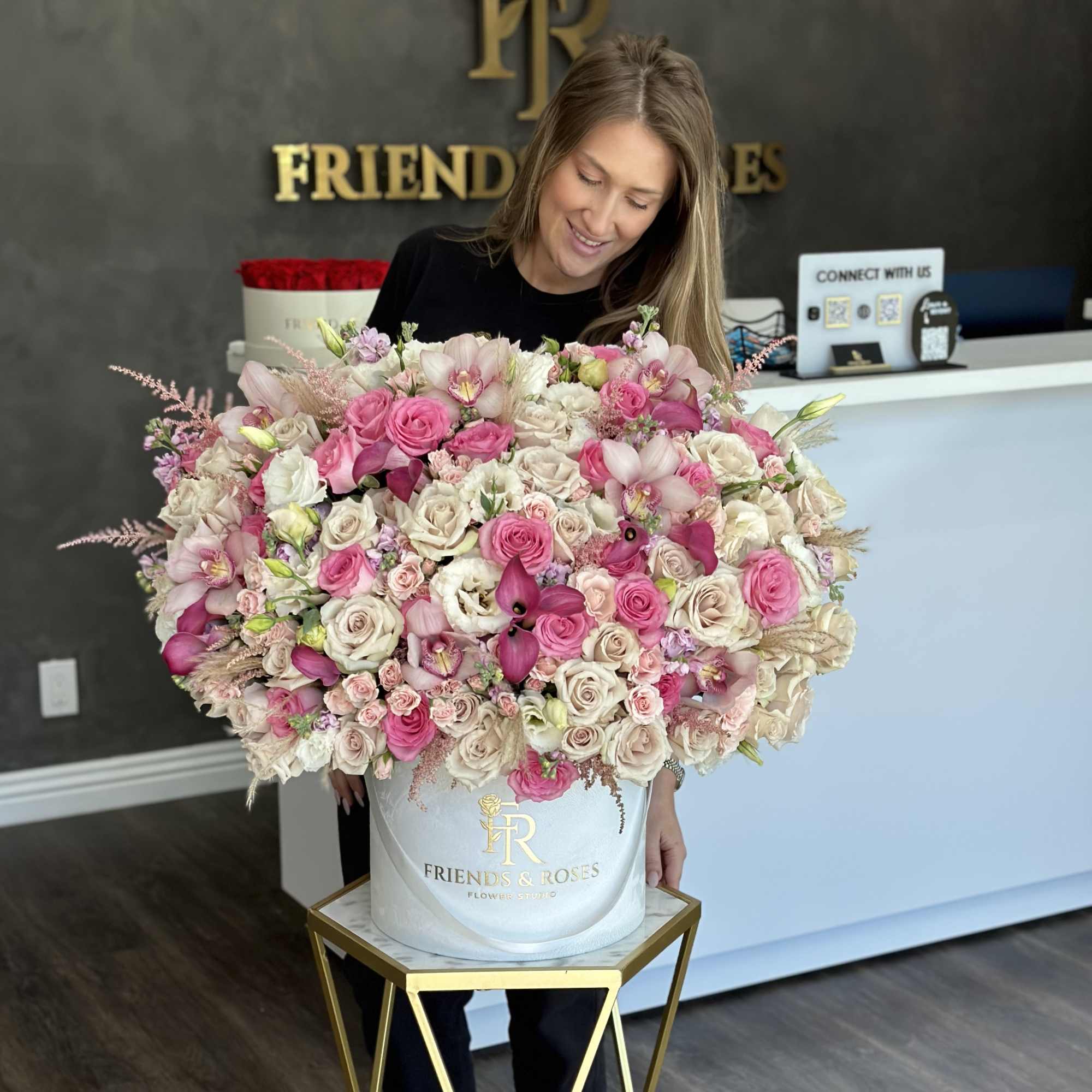 Large pink and white rose arrangement in a white hat box