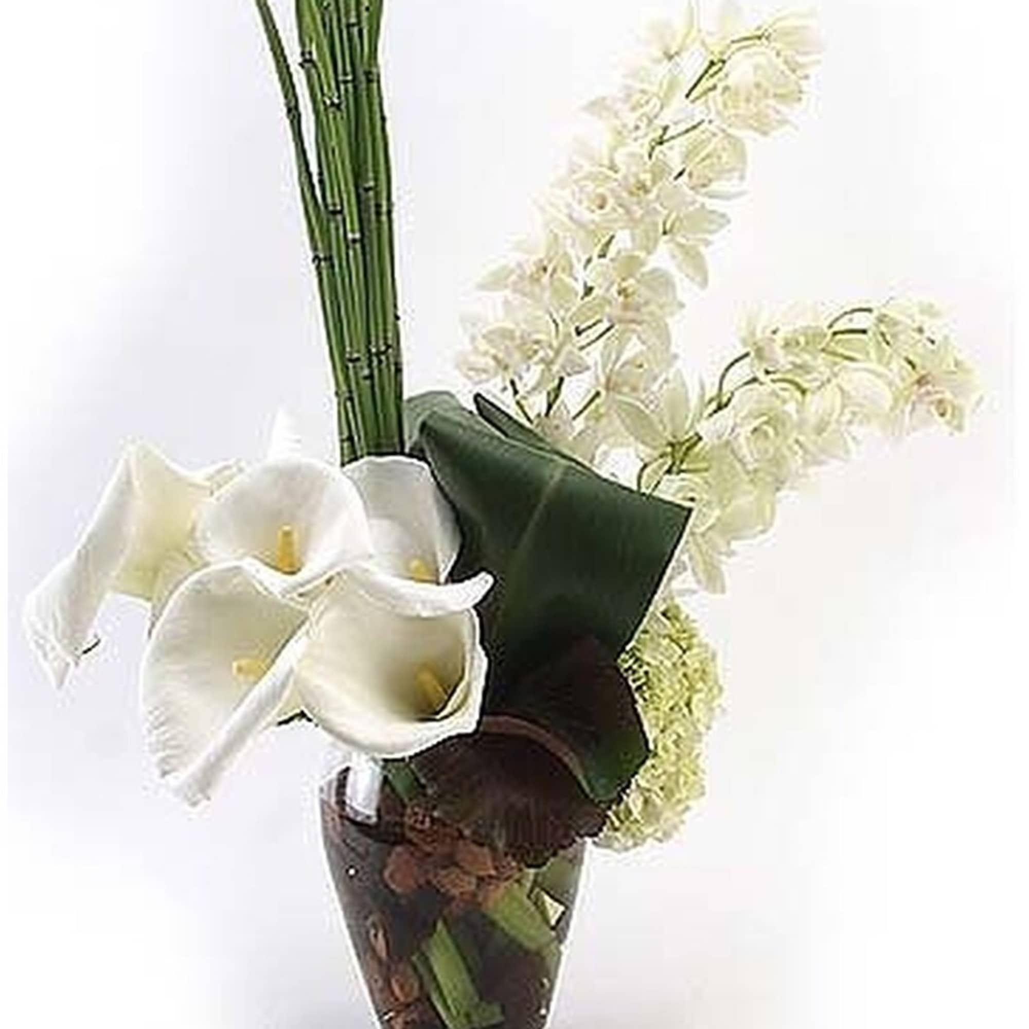 Tall modern arrangement of white calla lilies and orchids with vertical green stalks in a clear glass vase