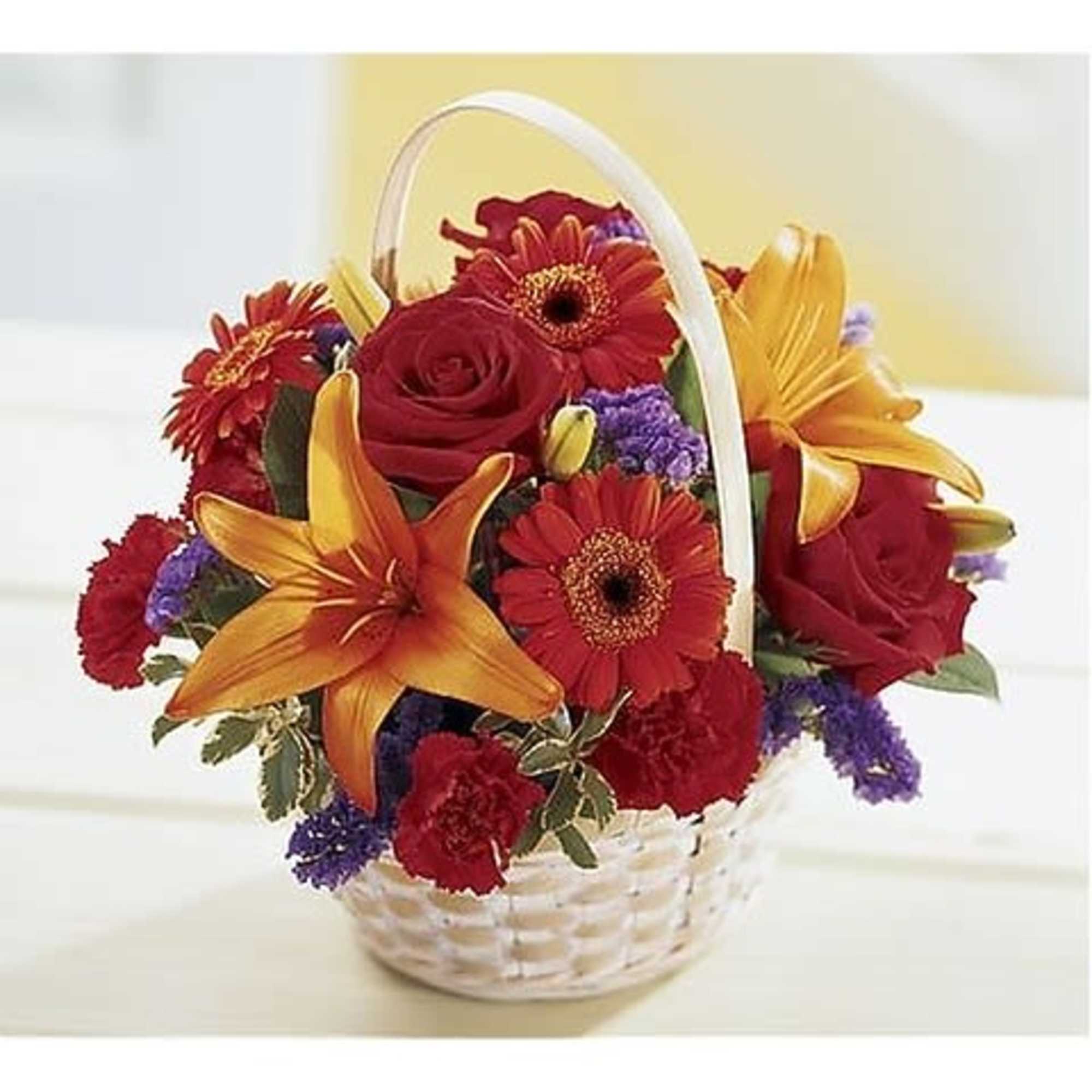 This basket abounds with red roses, orange mini Gerbera daisies, and orange