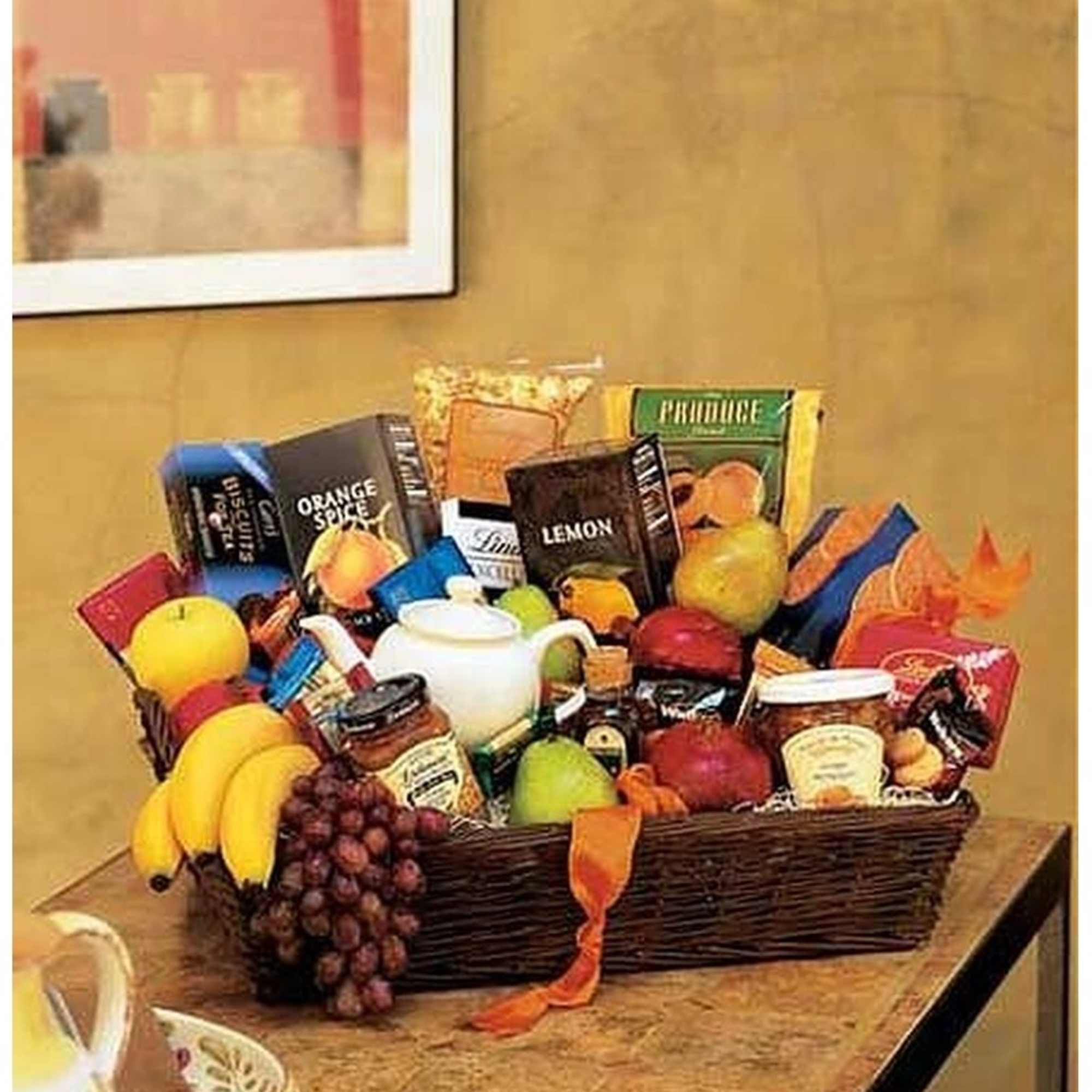Large wicker gift basket filled with assorted gourmet snacks and fresh fruit on a table