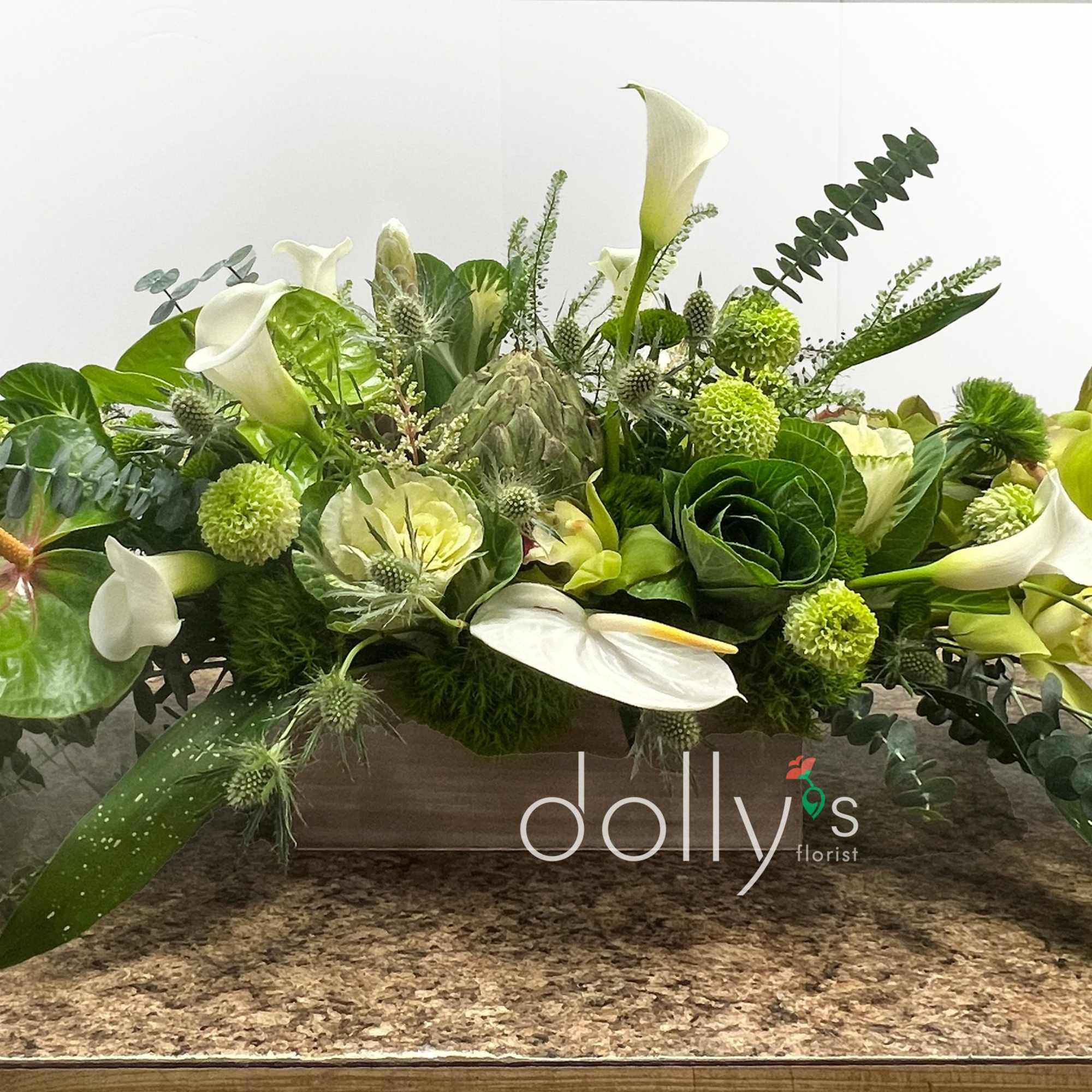 A long, low flower arrangement built in a rectangular wooden box, The