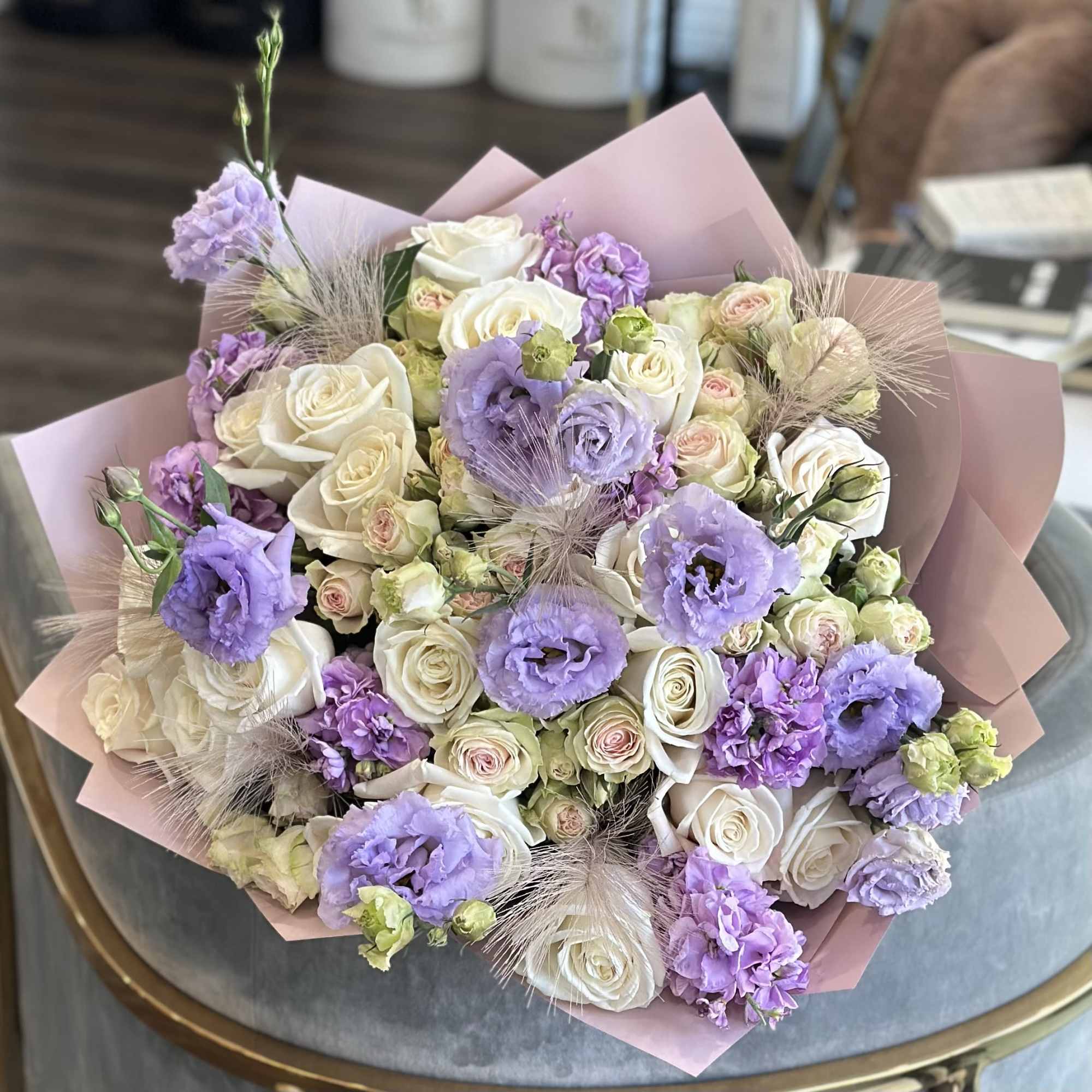 Bouquet of white roses and lavender flowers wrapped in pink paper