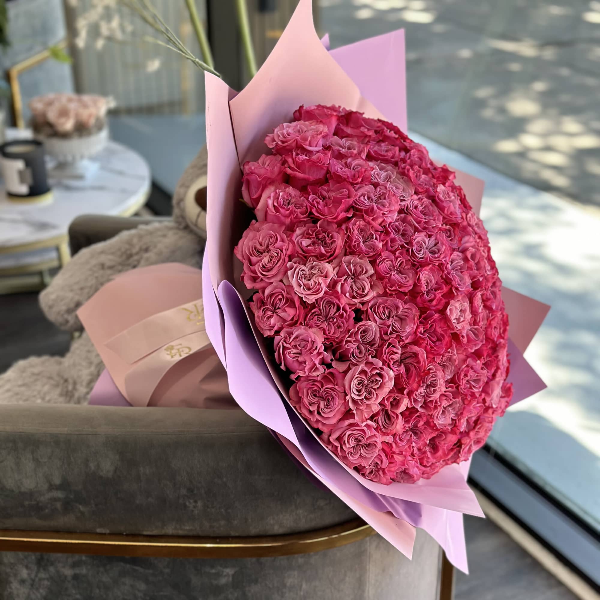 Large bouquet of bright pink roses wrapped in pink paper