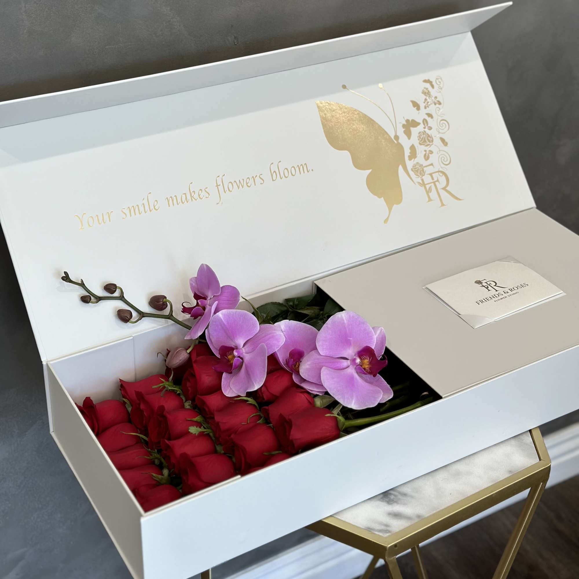 Box of red roses and pink orchids in a white gift box