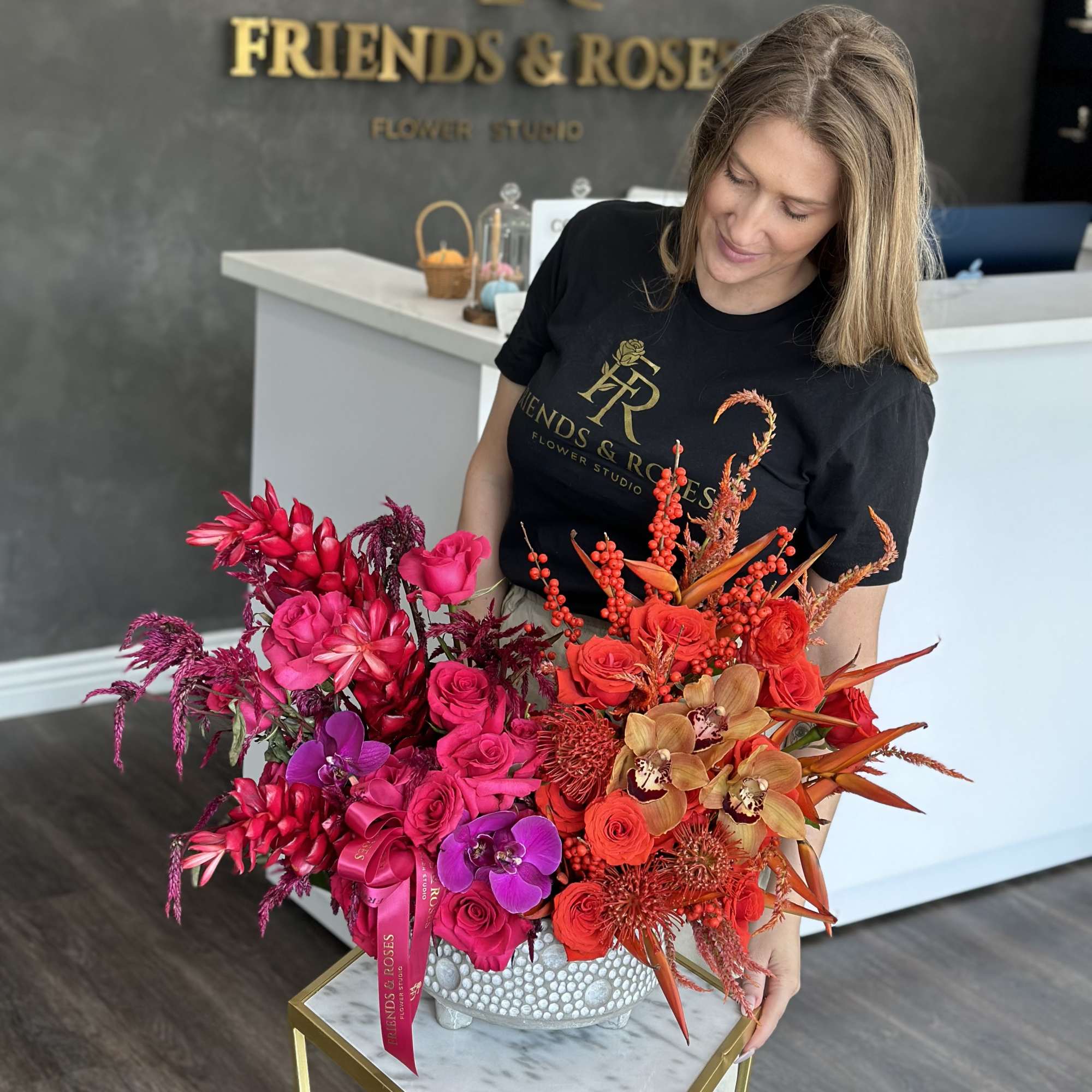 Large red, pink, and purple floral arrangement in a textured vase