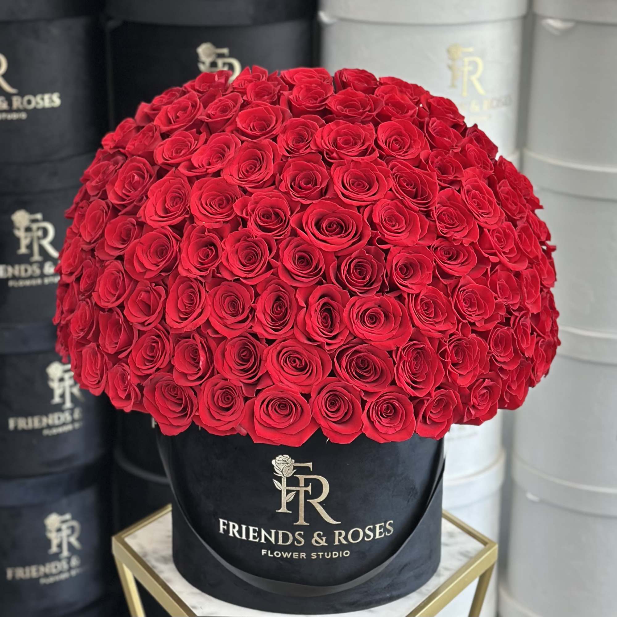 Large dome of red roses in a black hatbox.
