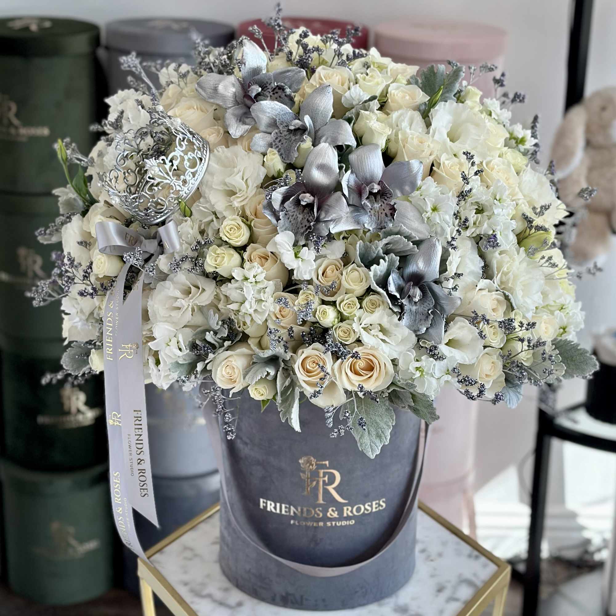 Cream and white rose bouquet with silver orchids in a gray hat box