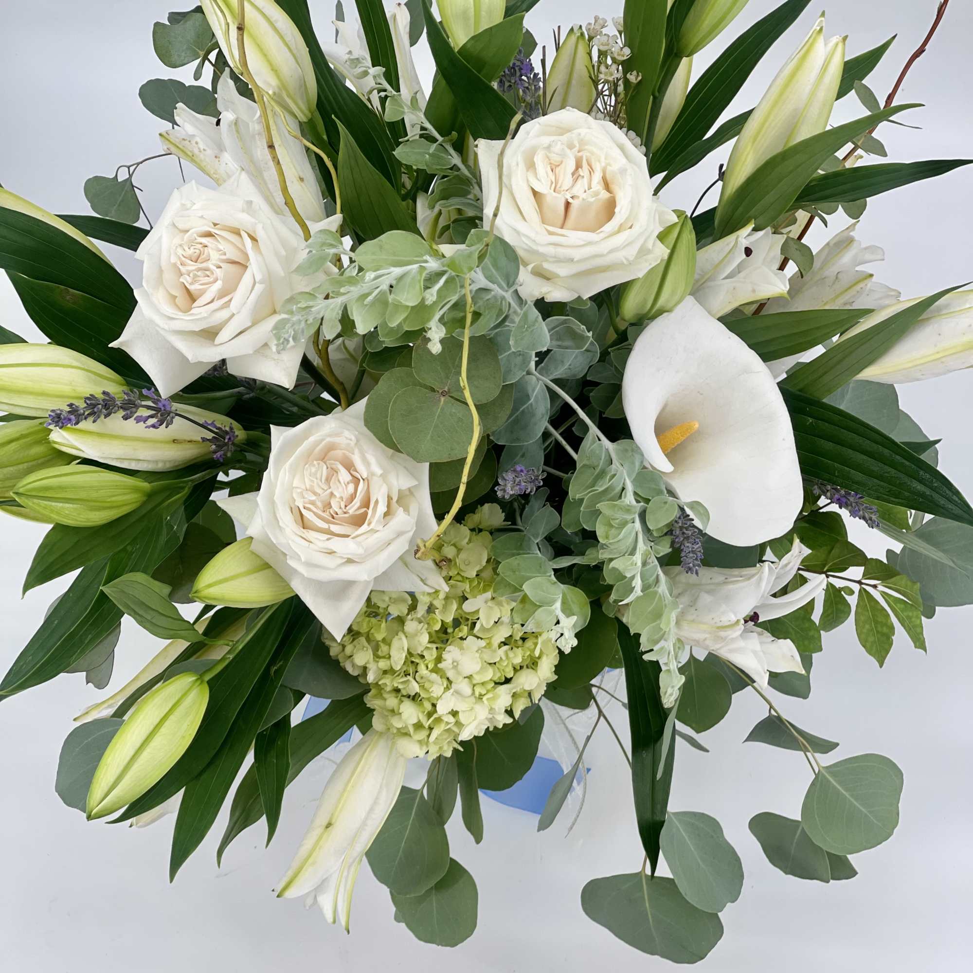 White roses, lilies, and calla lily in a lush bouquet