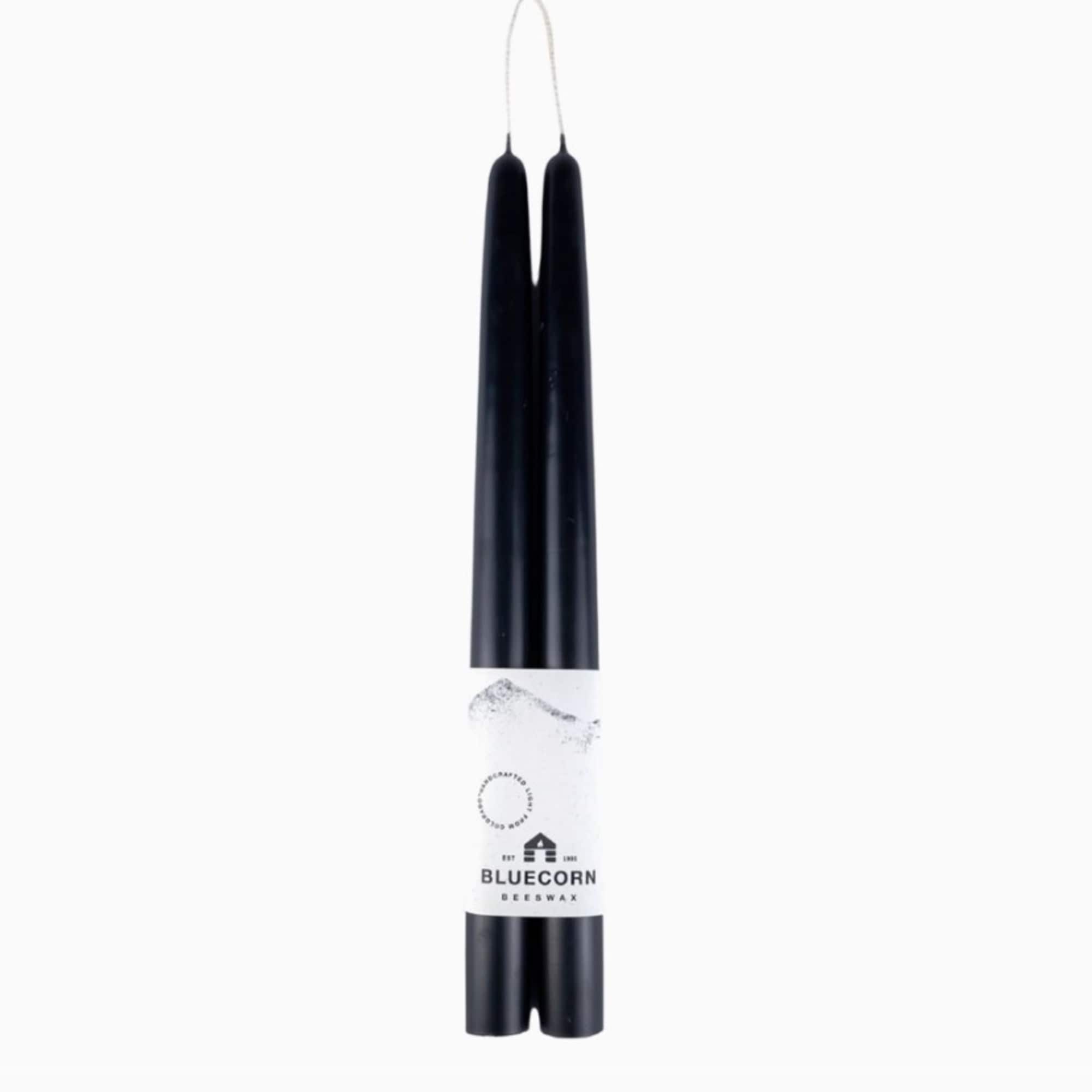 Pair of black taper candles joined by a wick with a white label band