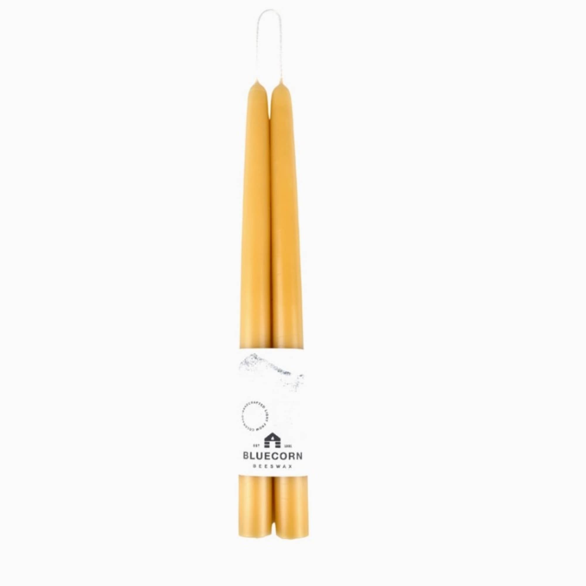Pair of honey-colored taper candles wrapped with a branded paper band