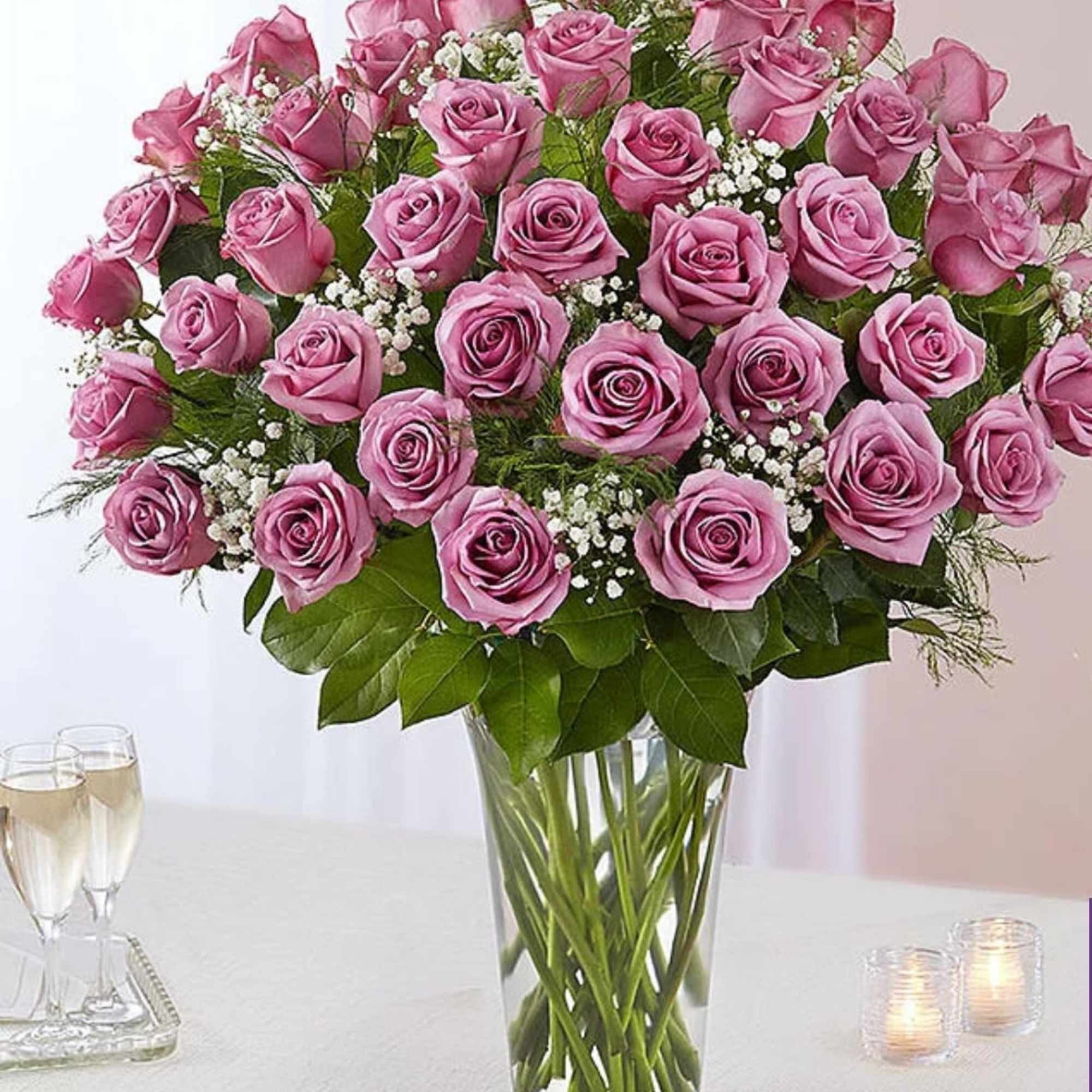 Pink rose bouquet in a clear glass vase with baby's breath