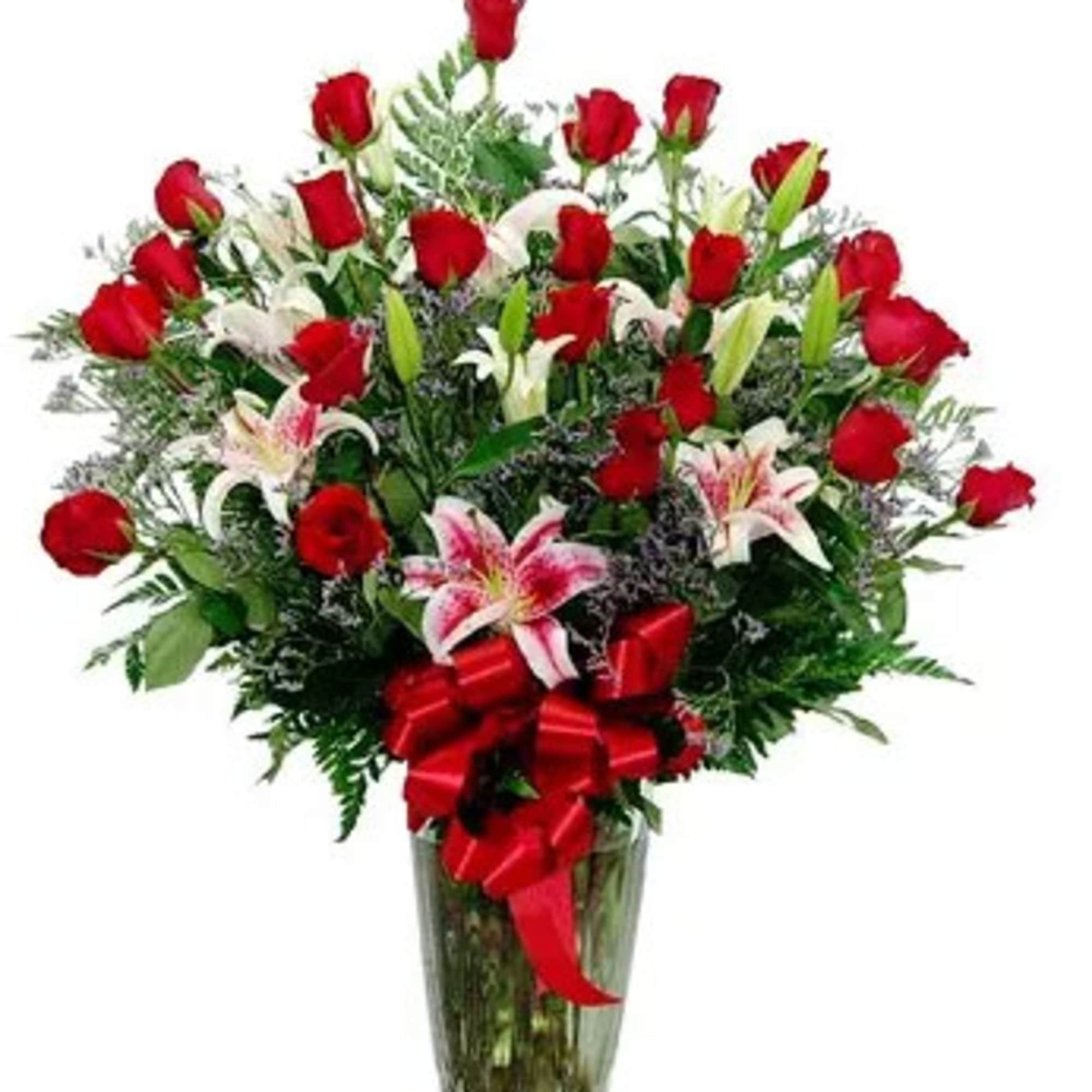 Bouquet of red roses and white lilies in a glass vase with a red ribbon