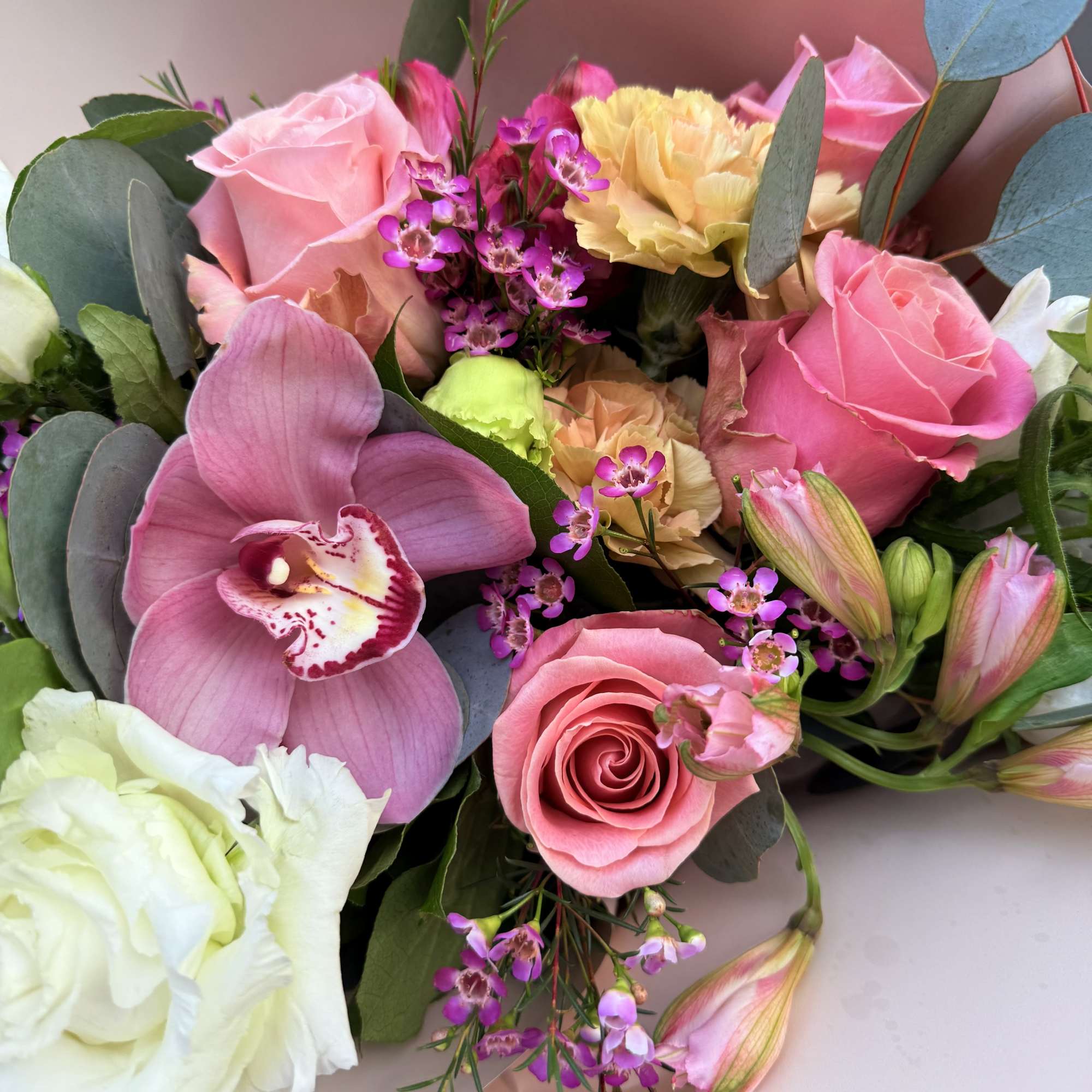 Pink and white bouquet with roses, orchids, and carnations