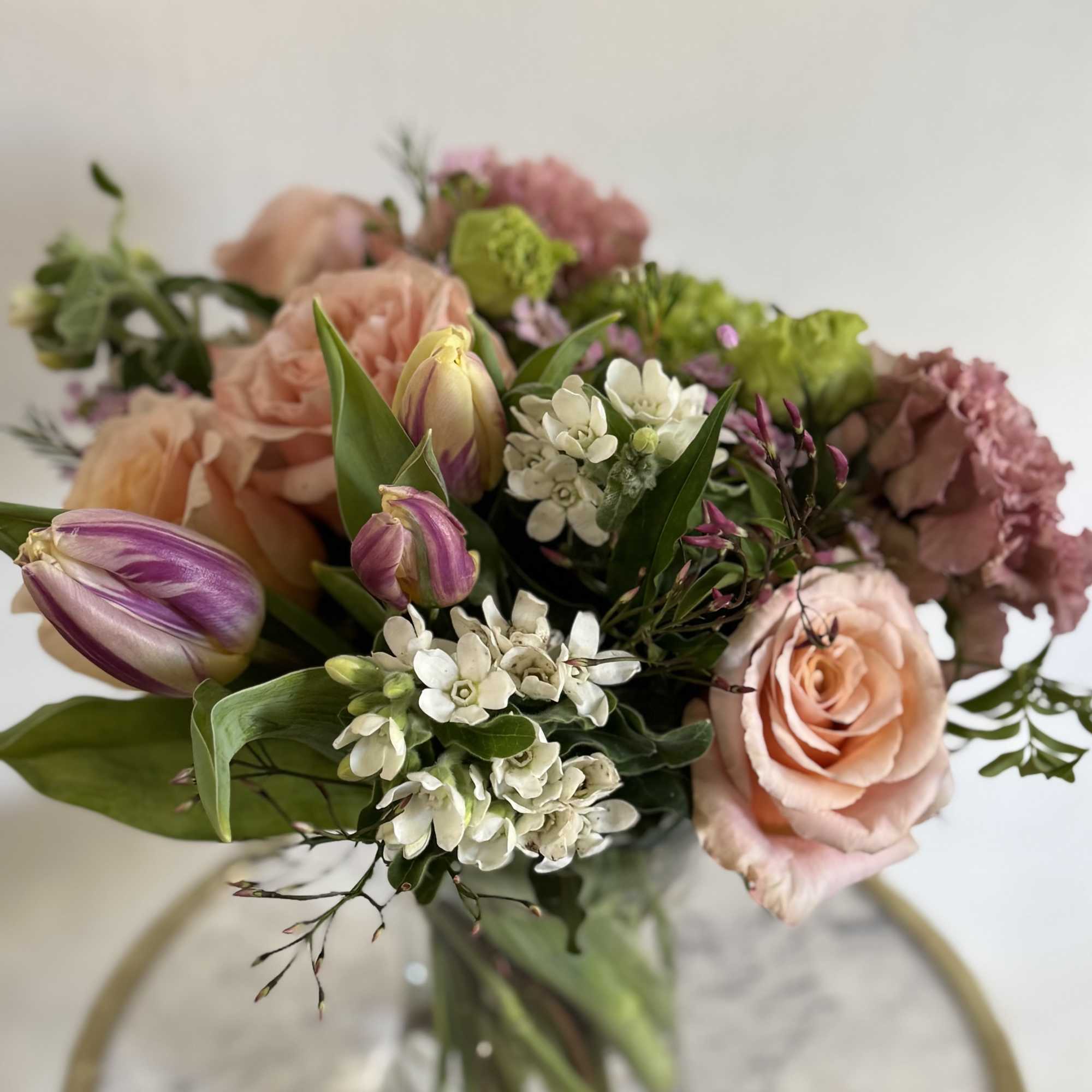 The mixed-color arrangement reads cheerful and romantic, the kind of vase bouquet