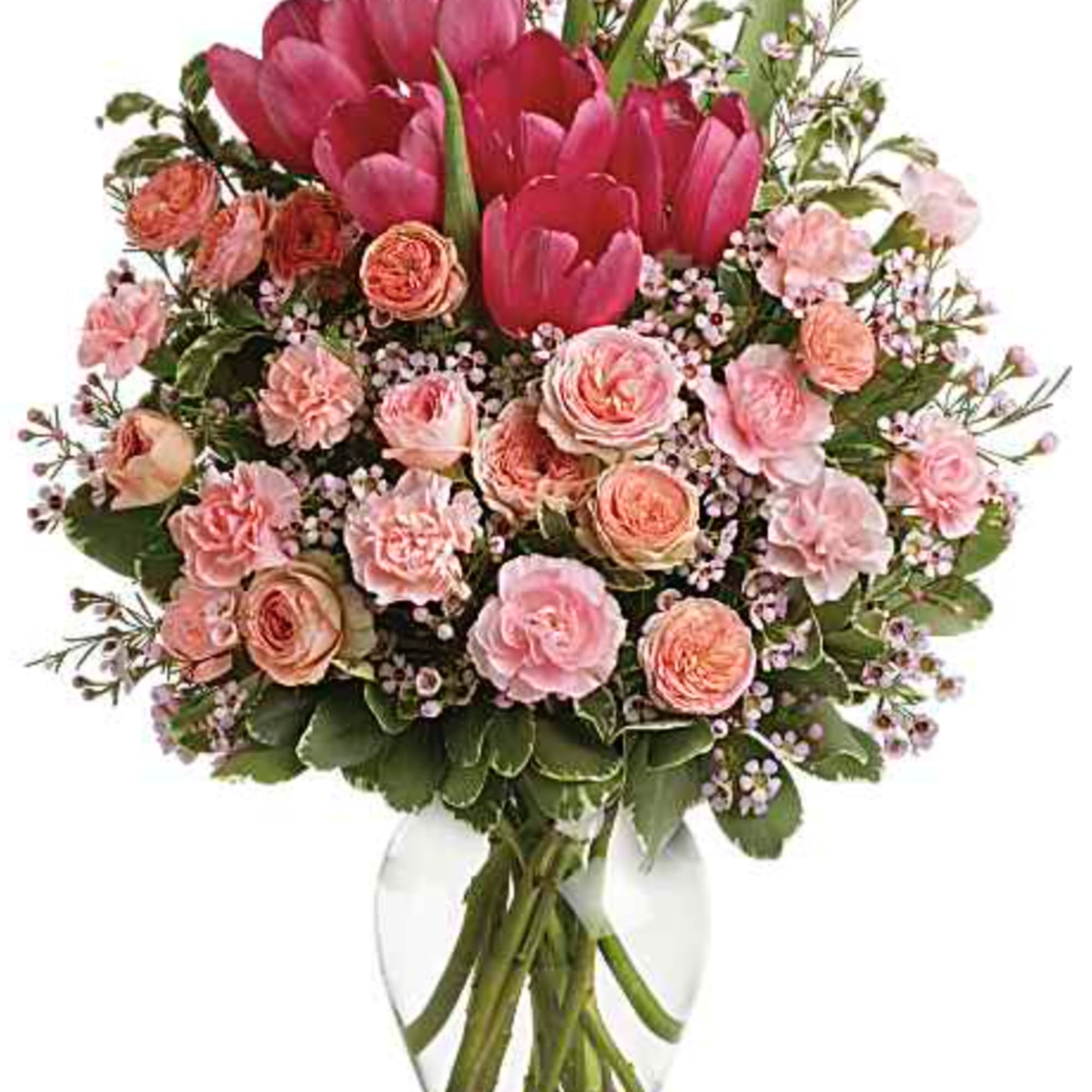 Spring into pink! Delicate roses, tulips and carnations fill a graceful vase
