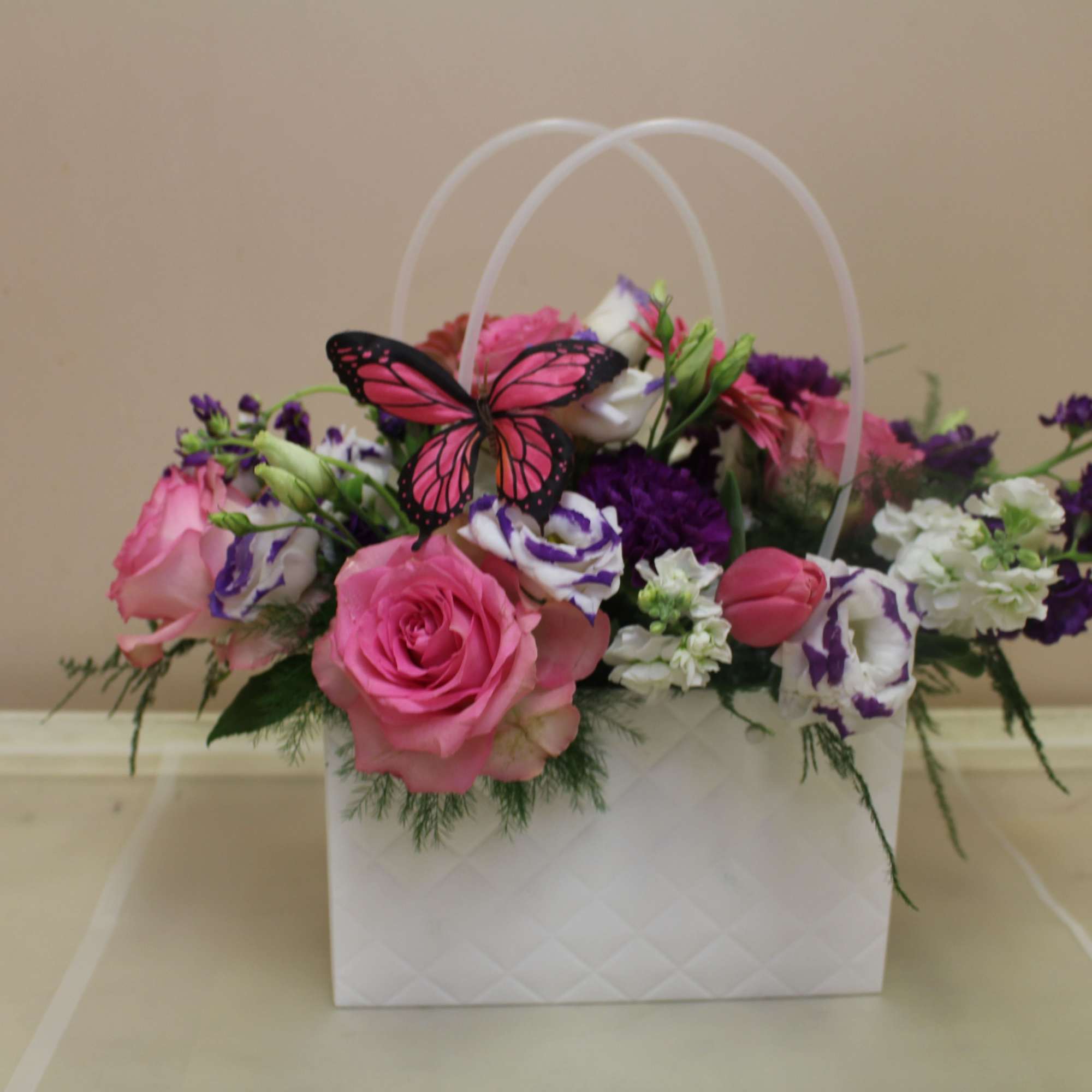 A bright decorative like pocketbook full of flowers, this floral arrangement is